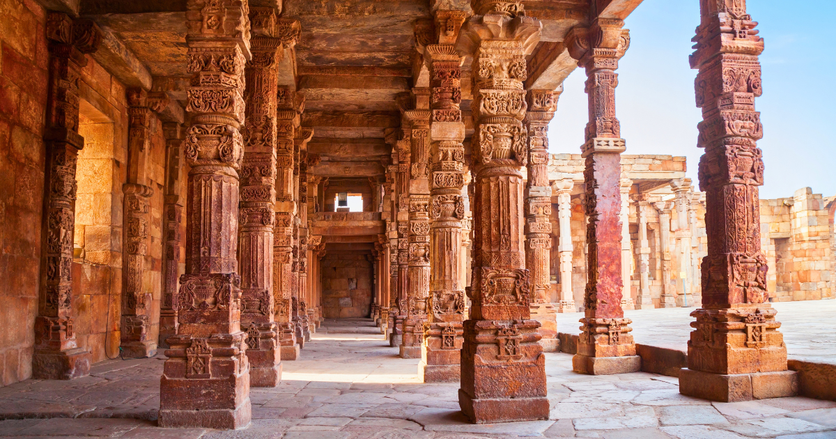 Rows of intricately carved stone columns inside the Quwwat-ul-Islam Mosque