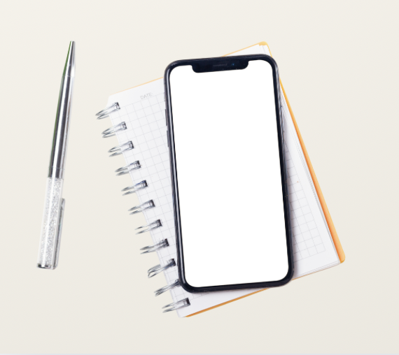 Un stylo, un téléphone intelligent avec un écran blanc, un carnet de notes et un livre avec une couverture orange, tous placés sur une surface claire.
