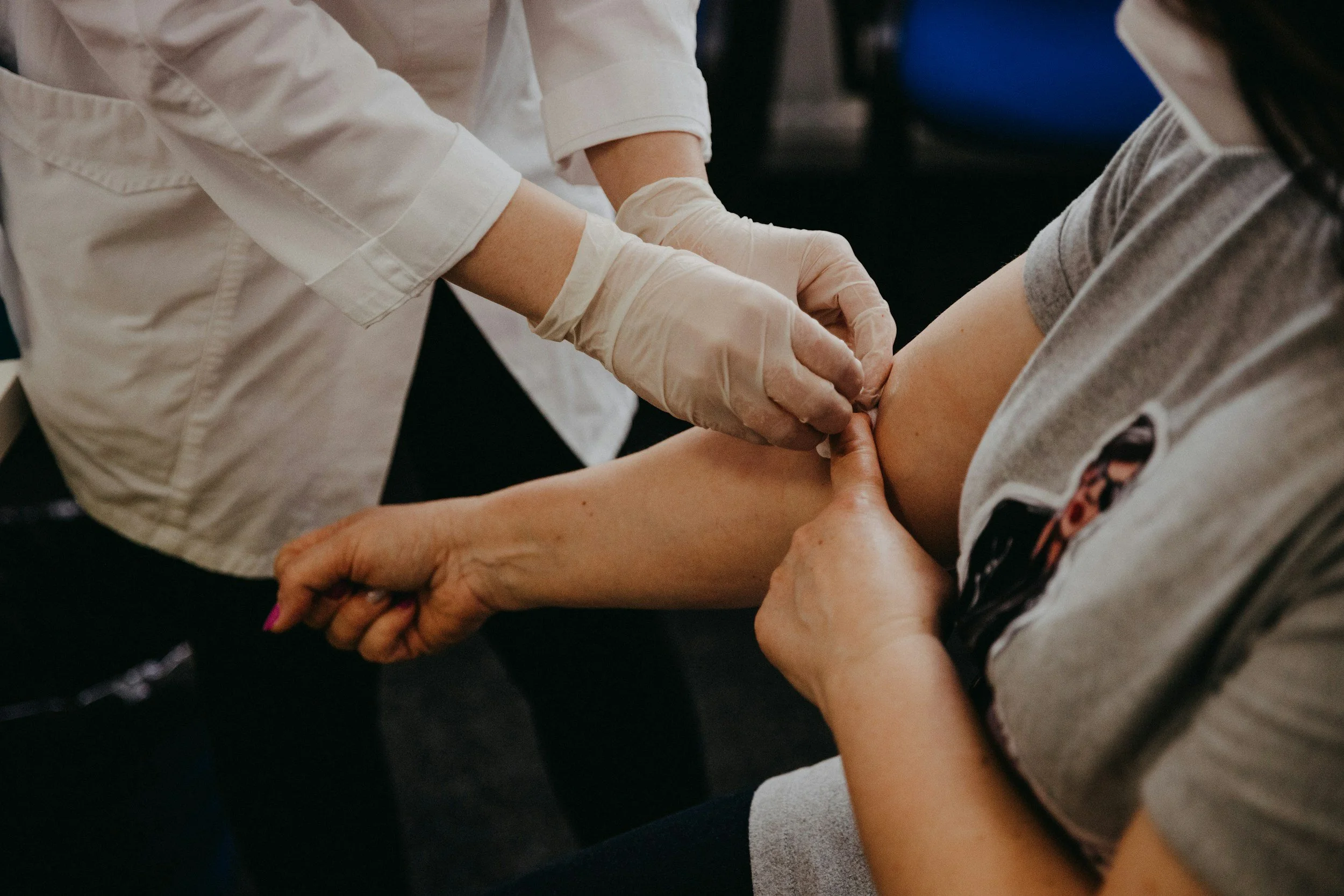 Une femme donne son sang dans une clinique à Deux-Montagnes, une infirmière aide et porte des gants pour le prélèvement sanguin.