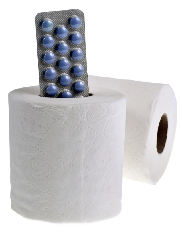 Deux rouleaux de papier toilette avec une plaquette de pilules bleues insérée dans un rouleau