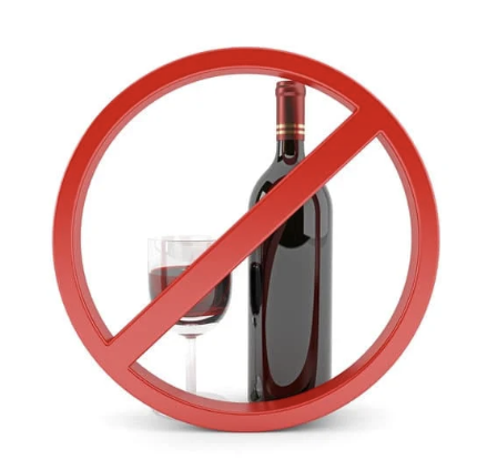 Une bouteille de vin et un verre de vin avec un symbole d'interdiction rouge superposé.