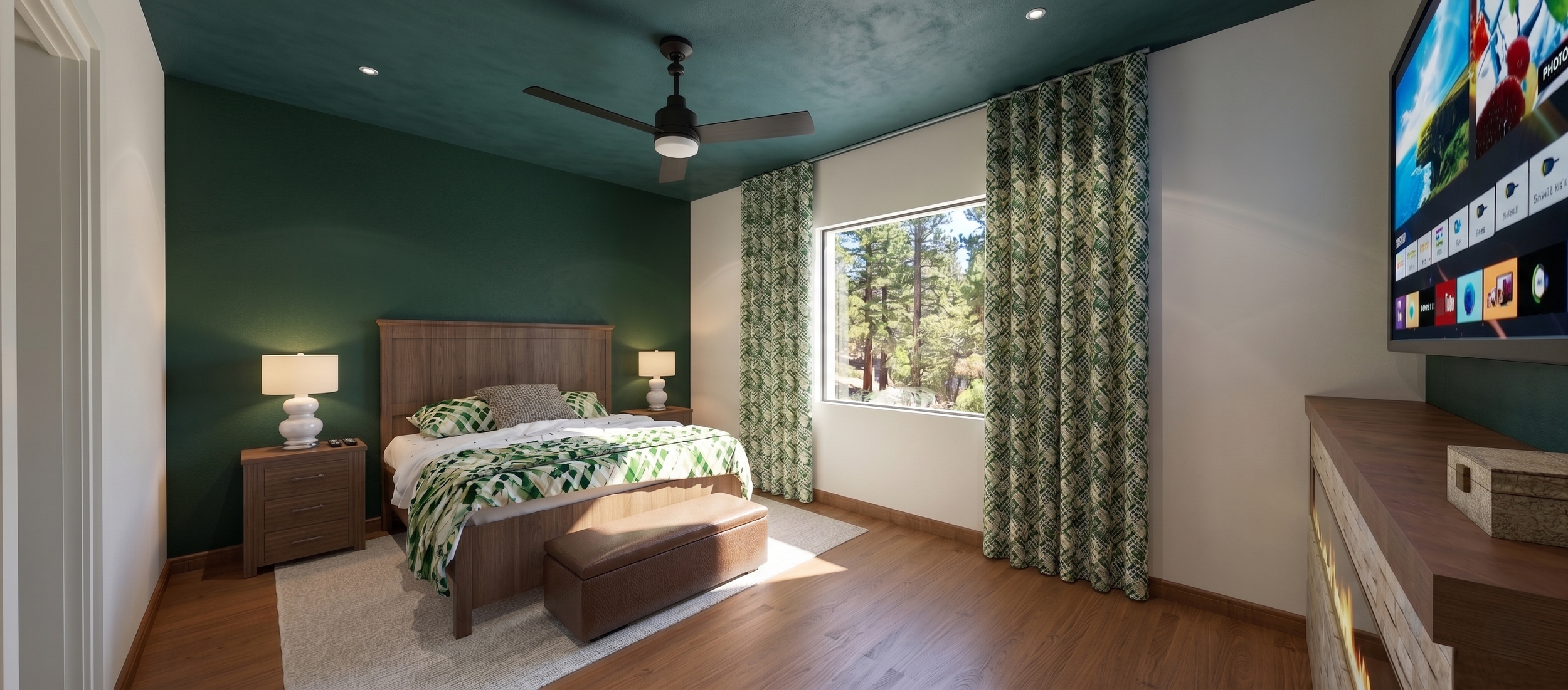 A bedroom with a green accent wall behind the bed, which has a wooden headboard. Two nightstands with lamps flank the bed. There is a window with checked curtains letting in natural light, showing trees outside. A ceiling fan is above, and a flat-scr