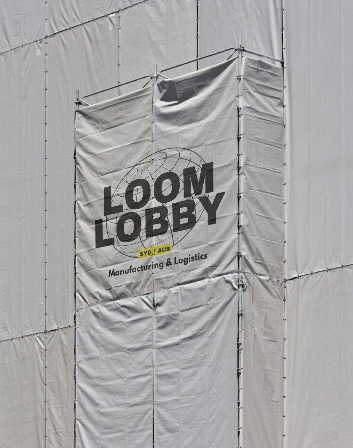 A large white banner with the logo and text 'LOOM LOBBY' hanging on a constructing covered with a white tarp. The banner also says 'SYD. * AUS Manufacturing & Logistics'.