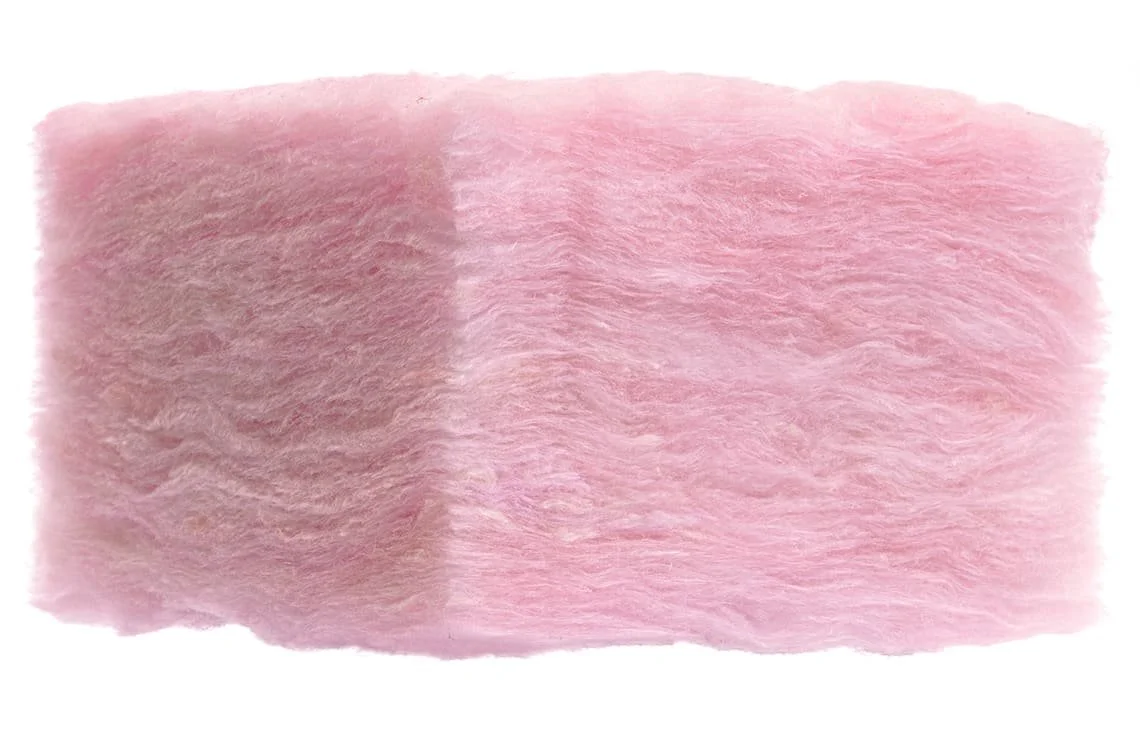 Pink matted fiberglass insulation piece against a white background.