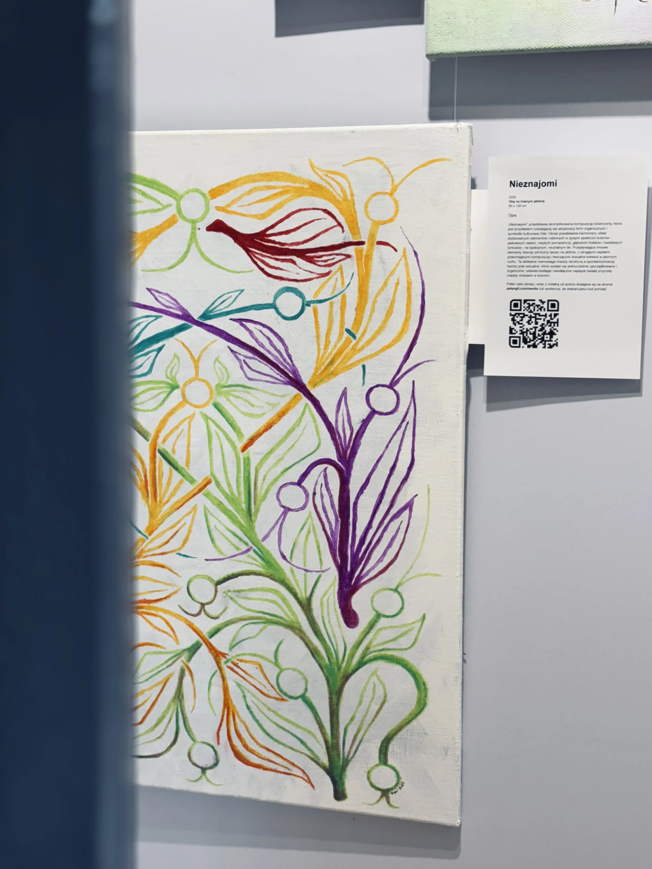 Colorful botanical illustration with interconnected stems, leaves, and berries on a white canvas, displayed at an exhibition with a nearby informational placard containing a QR code.