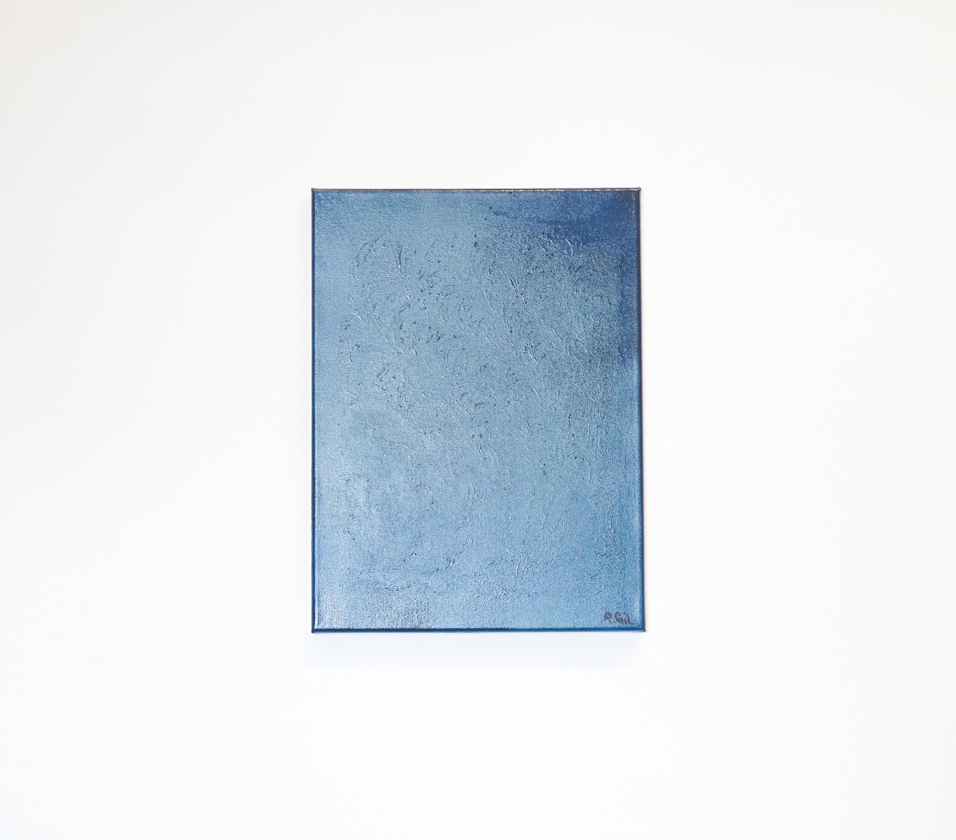 A blue textured artwork on a white wall.