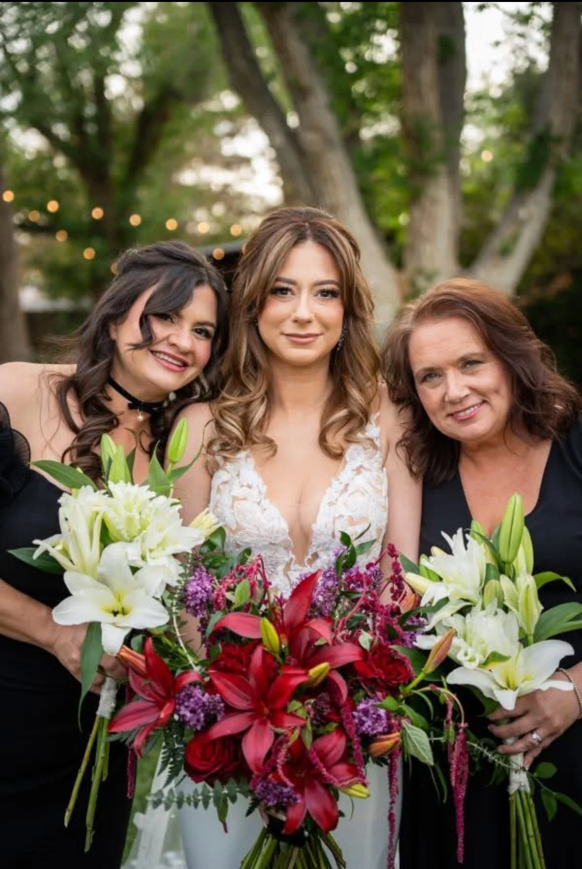 Woman with styled hair and makeup, smiling, in a room with vertical blinds.