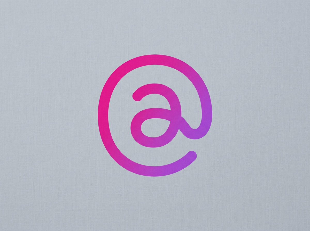A stylized purple and pink at symbol (@) on a light grey background.