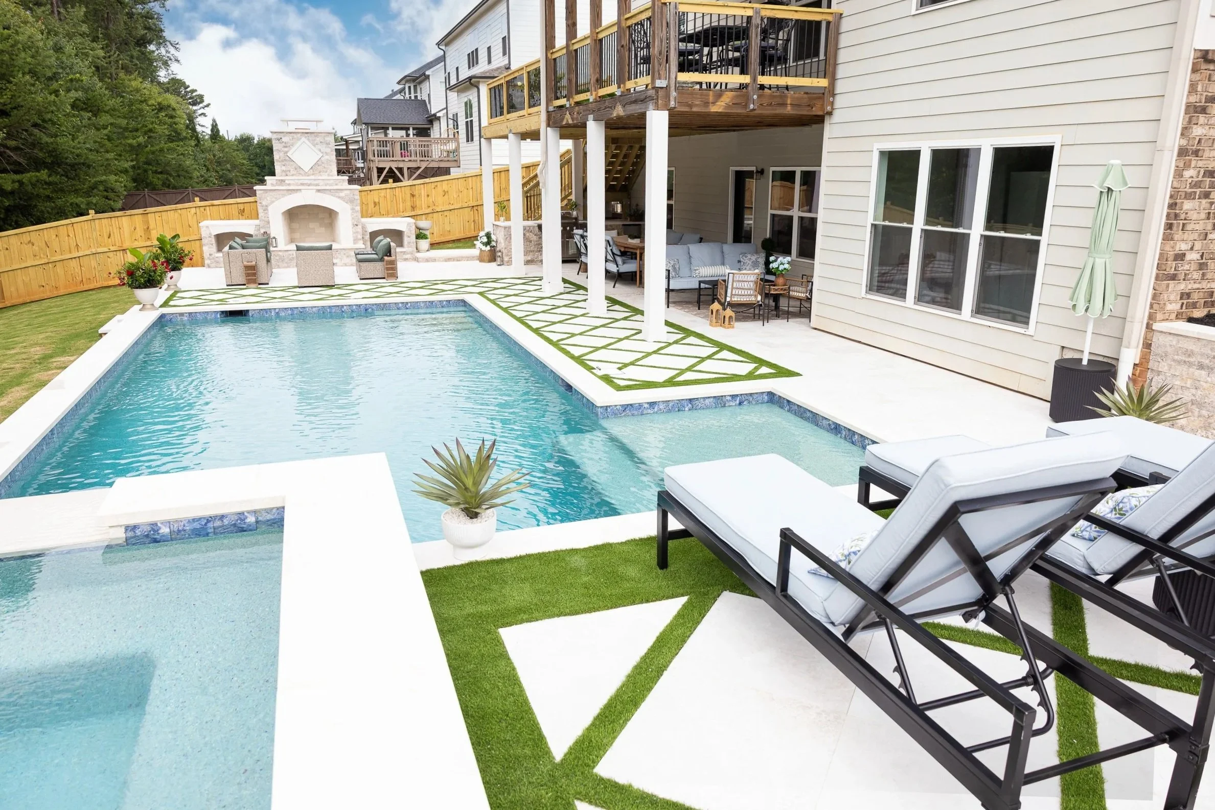 Inground pool and spa with artificial turf and pavers
