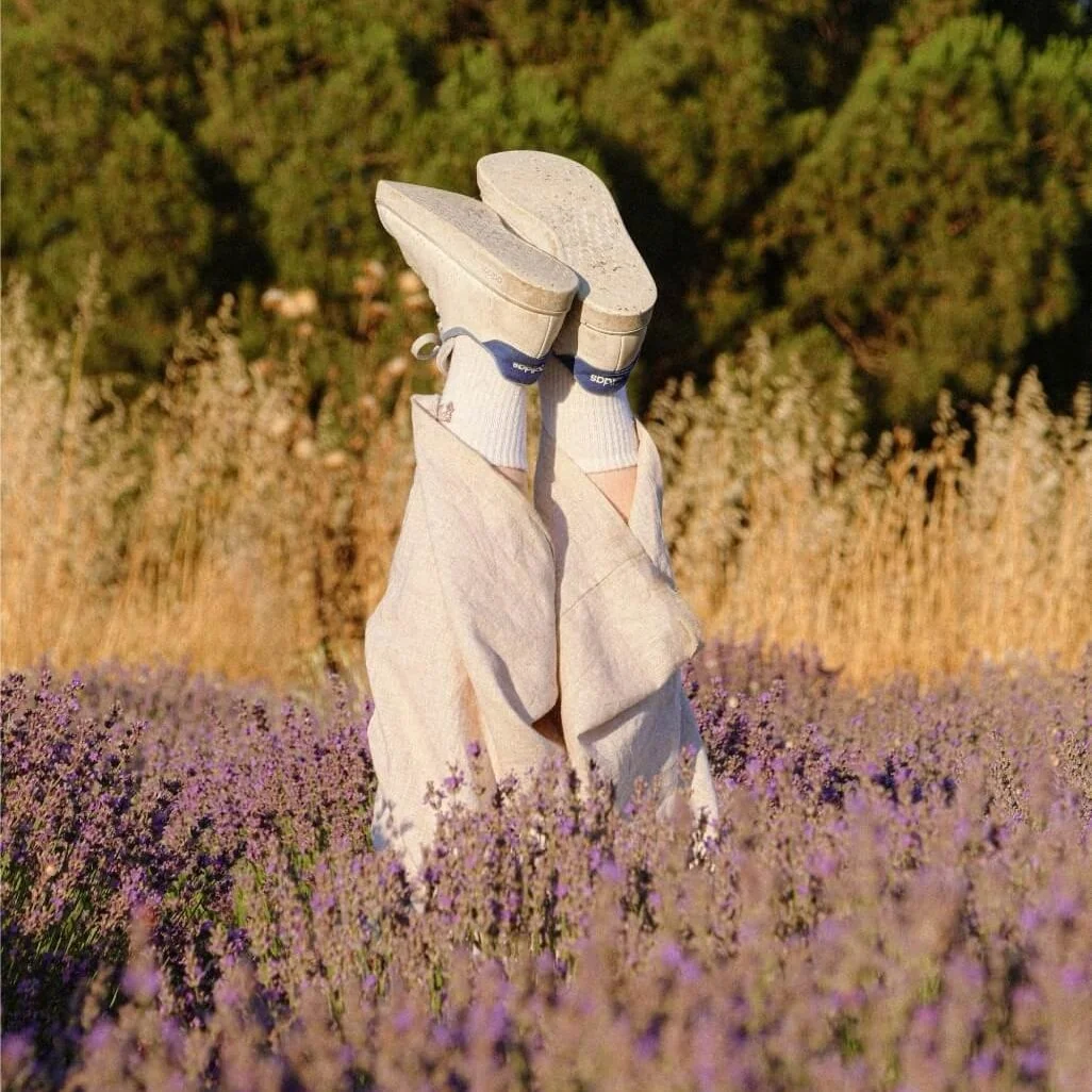 Person resting among lavender, representing relaxation and wellbeing in holistic therapy.