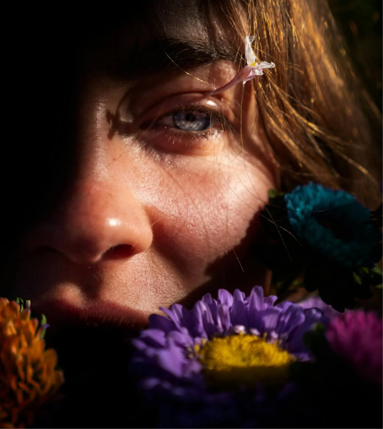 Woman surrounded by flowers in a reflective moment, illustrating emotions explored in depression therapy.
