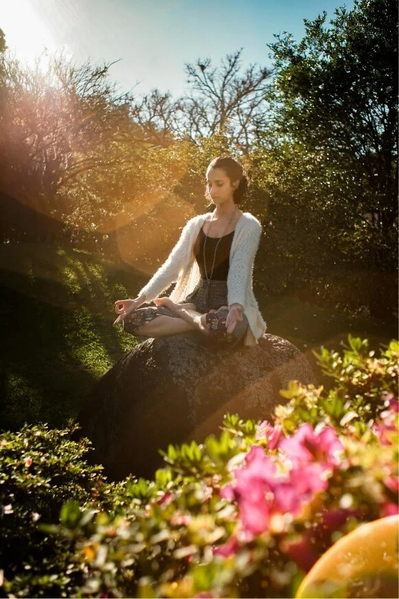 Woman meditating outdoors, illustrating mindfulness and calm in anxiety therapy.