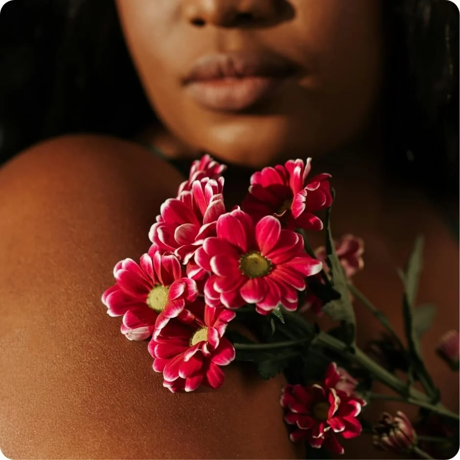 Woman holding flowers close to her body, representing self-compassion and emotional healing in depression therapy.