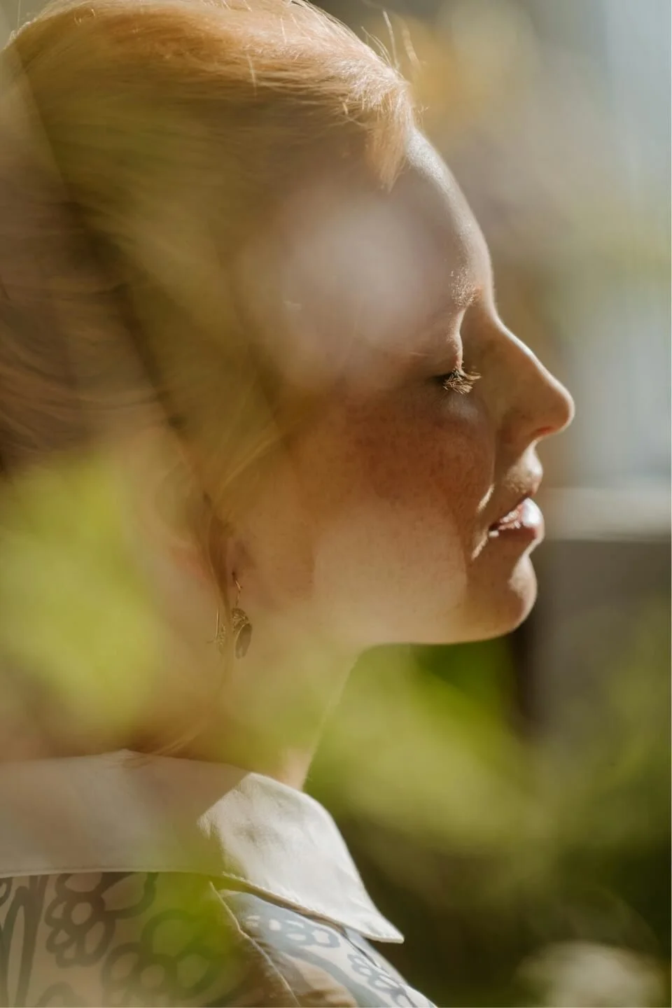 Woman with eyes closed in soft natural light, illustrating reflection and healing in depression therapy.
