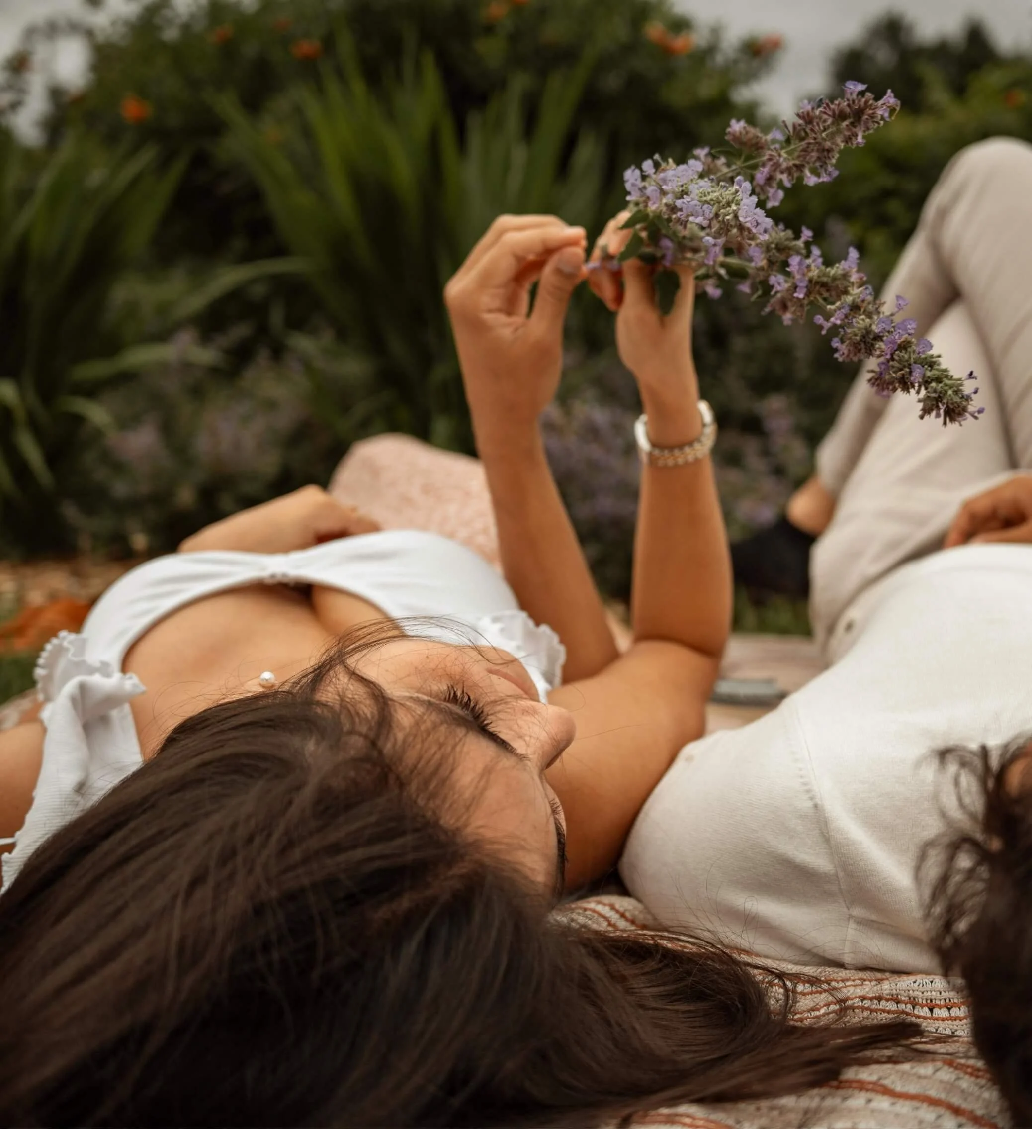 Two people relaxing together outdoors, representing closeness and emotional connection in couples therapy.