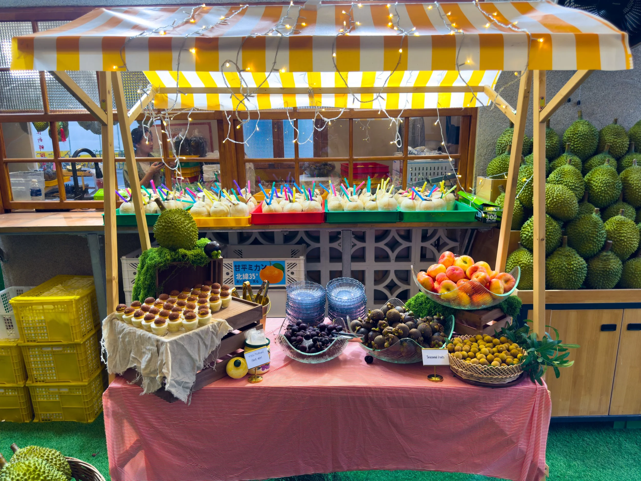 seasonal fruits and durian pastry are placed on a wooden cart with fresh coconuts at the back during a durian party event at Ms Durian