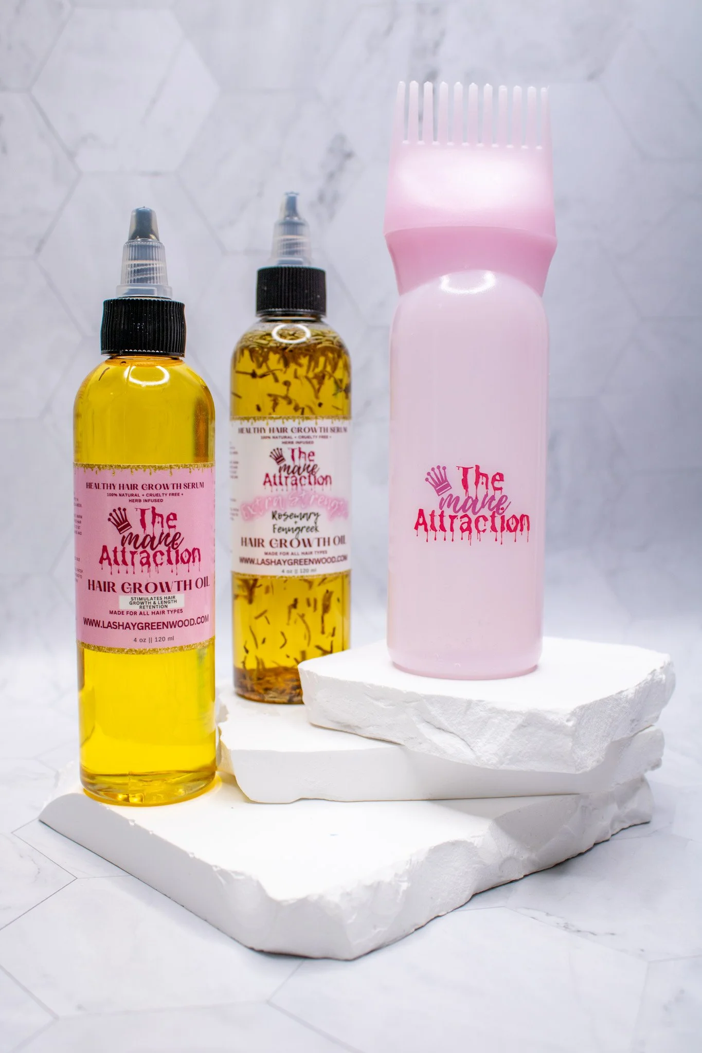 Hair growth serums and oil bottles on white textured trays against a white hexagonal tiled background.