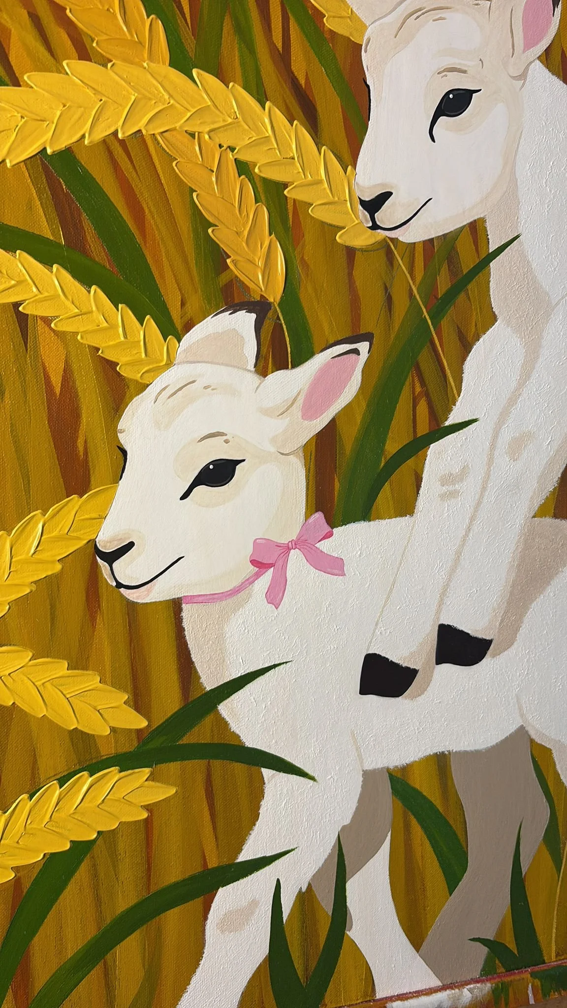 Painting of two white goats among golden wheat stalks, one with a pink bow around its neck.