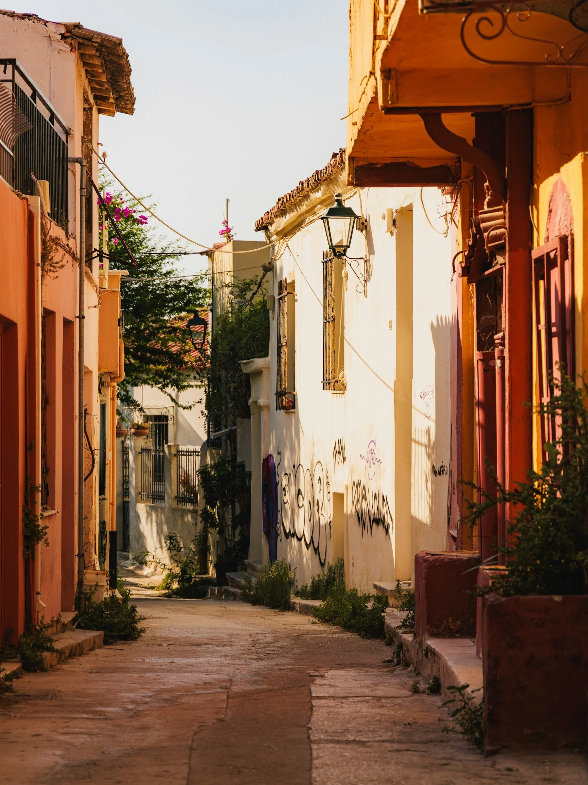 an image of a sunny day in Plaka, Athens with sun shining on the neoclassical buildings