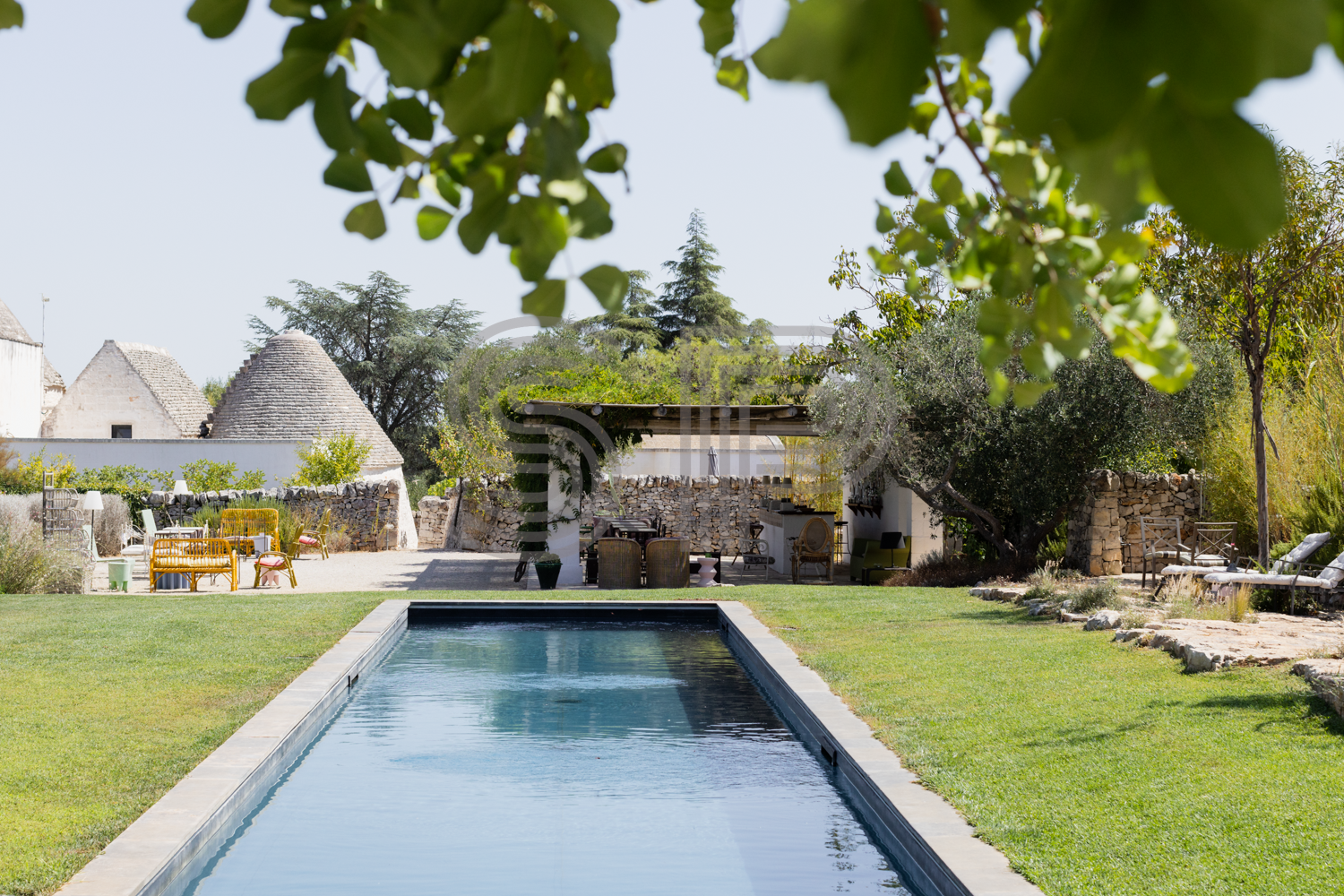 Traditional Trullo shoot location in Puglia with swimming pool, large lawn, rustic stone terraces and Mediterranean country setting
