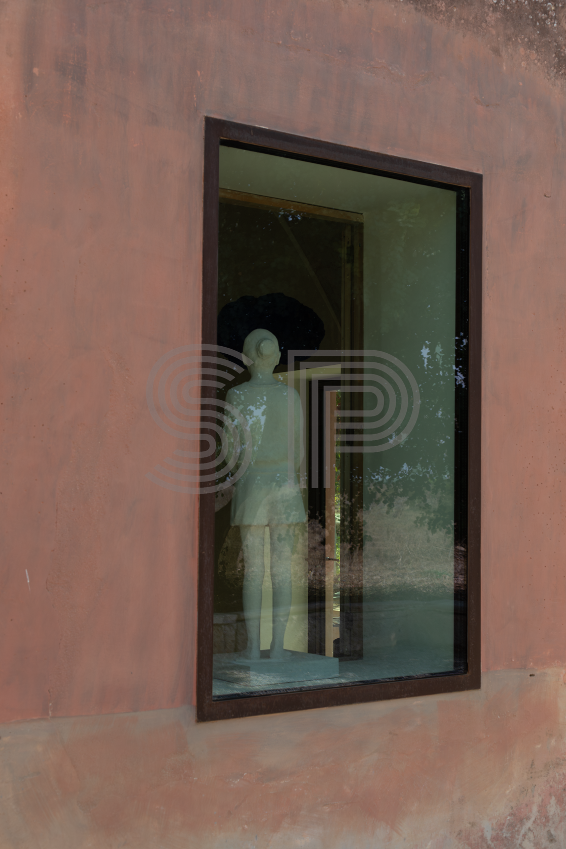 Puglia shoot location with pink-toned architecture, dark-framed window and sculptural detail
