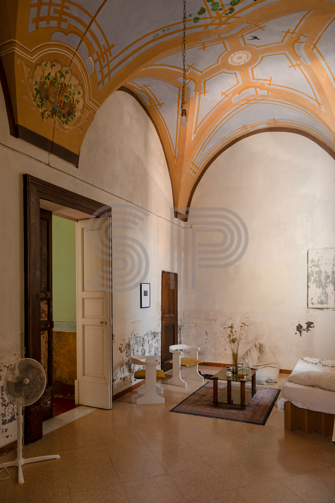 Palazzo interior with decorative frescoed vaulted ceiling, distressed plaster walls and grand proportions.