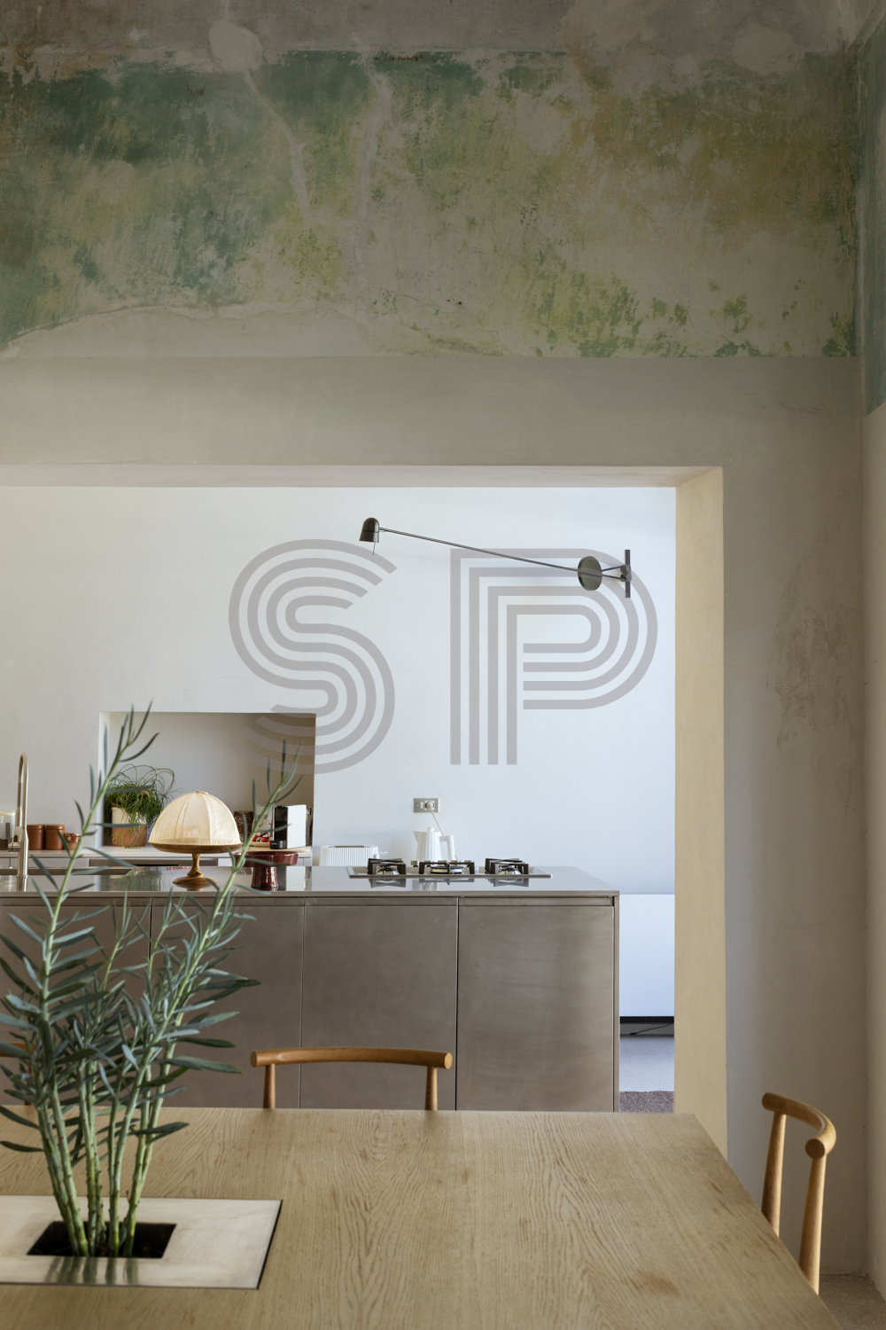 Puglia Palazzo interior with star-vaulted architecture, distressed lime plaster walls and contemporary stainless steel kitchen