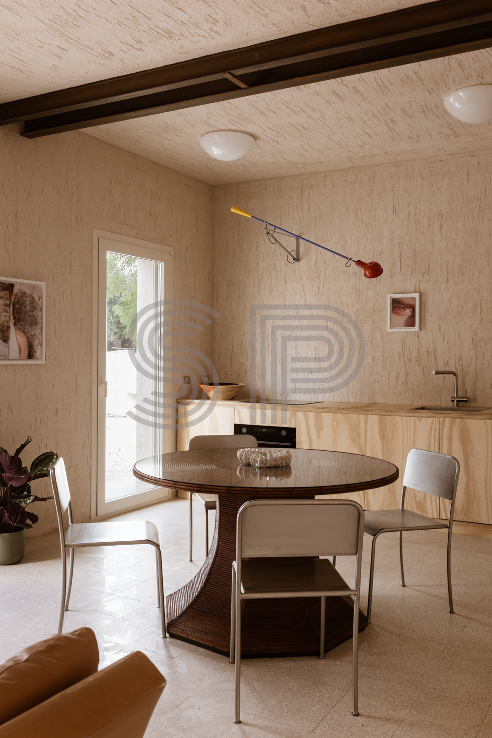 Contemporary open-plan interior with textured lime walls, timber kitchen and dining area.