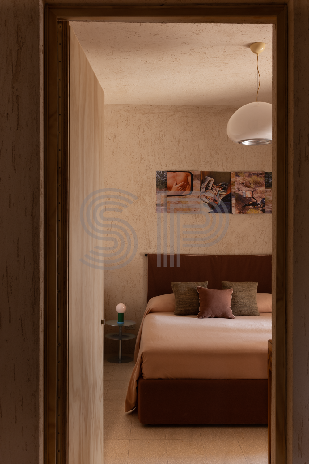 Minimal bedroom with textured lime walls and warm contemporary furnishings.