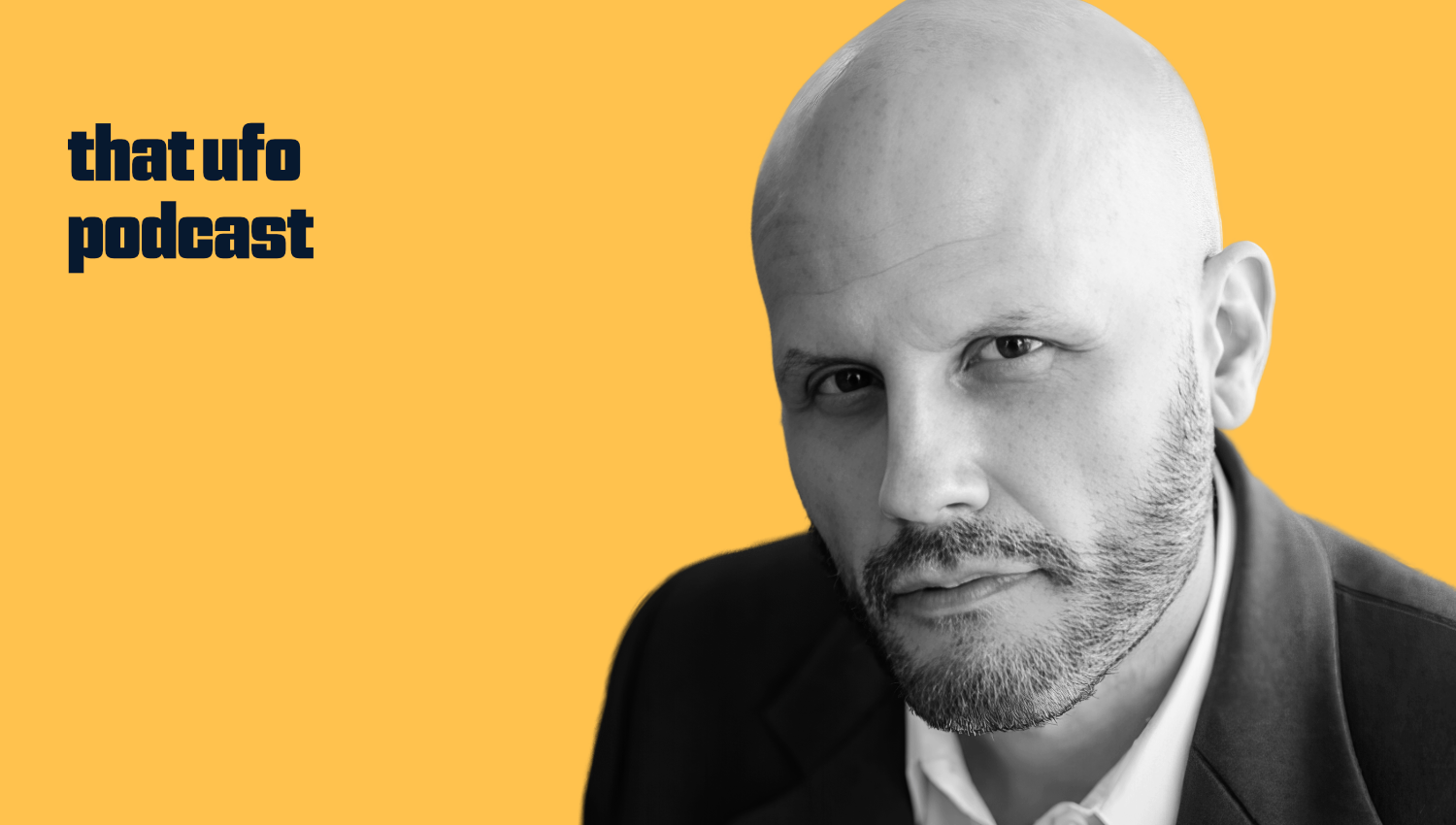 Black and white portrait of a man with a bald head and beard, wearing a dark suit jacket over a white shirt, against a yellow background with text "that ufo podcast" on the left side.