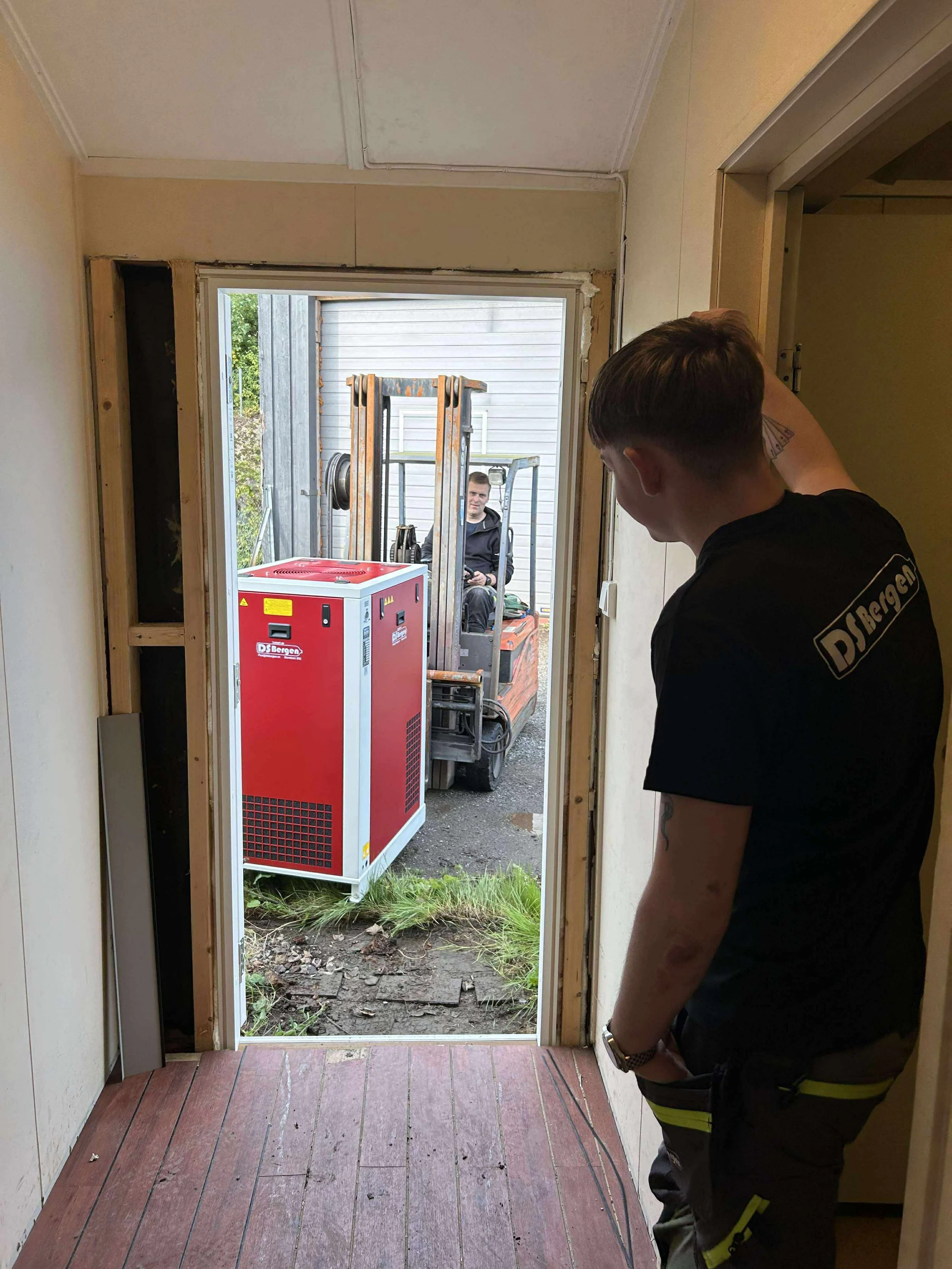 kompressor kjøres med truck. mann i forgrunnen.