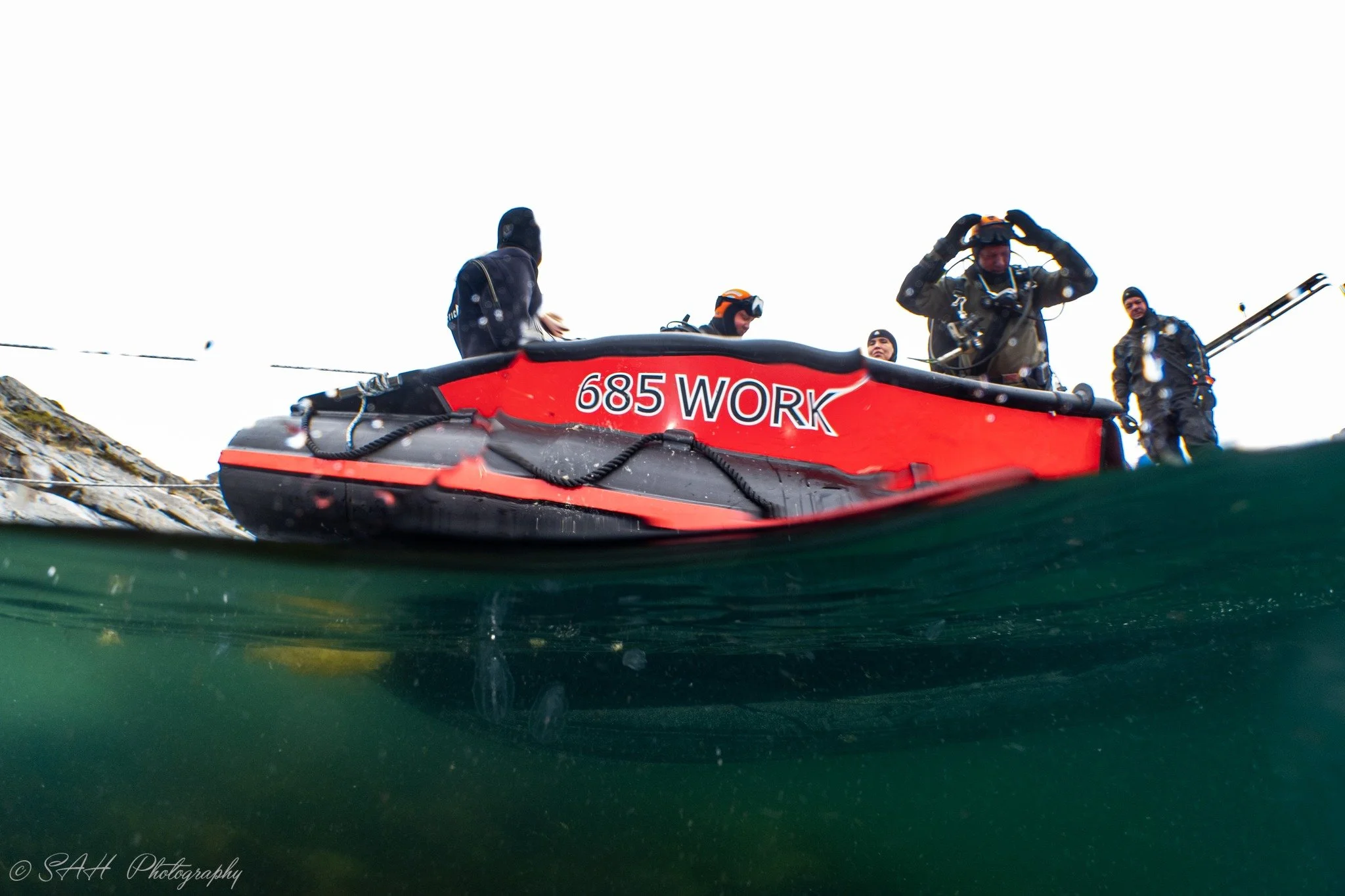 en rød båt med dykkere i.