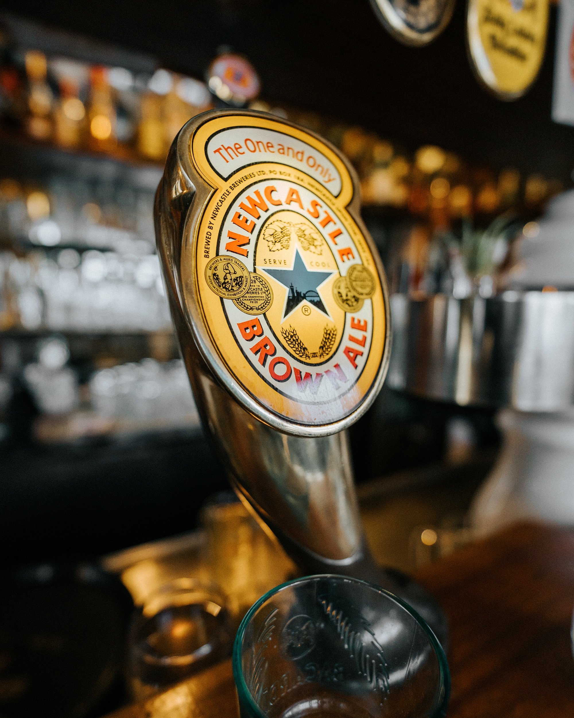 Zapfhahn für Newcastle Brown Ale in einer Bar, unscharfer Hintergrund. Dreieck Oldenburg