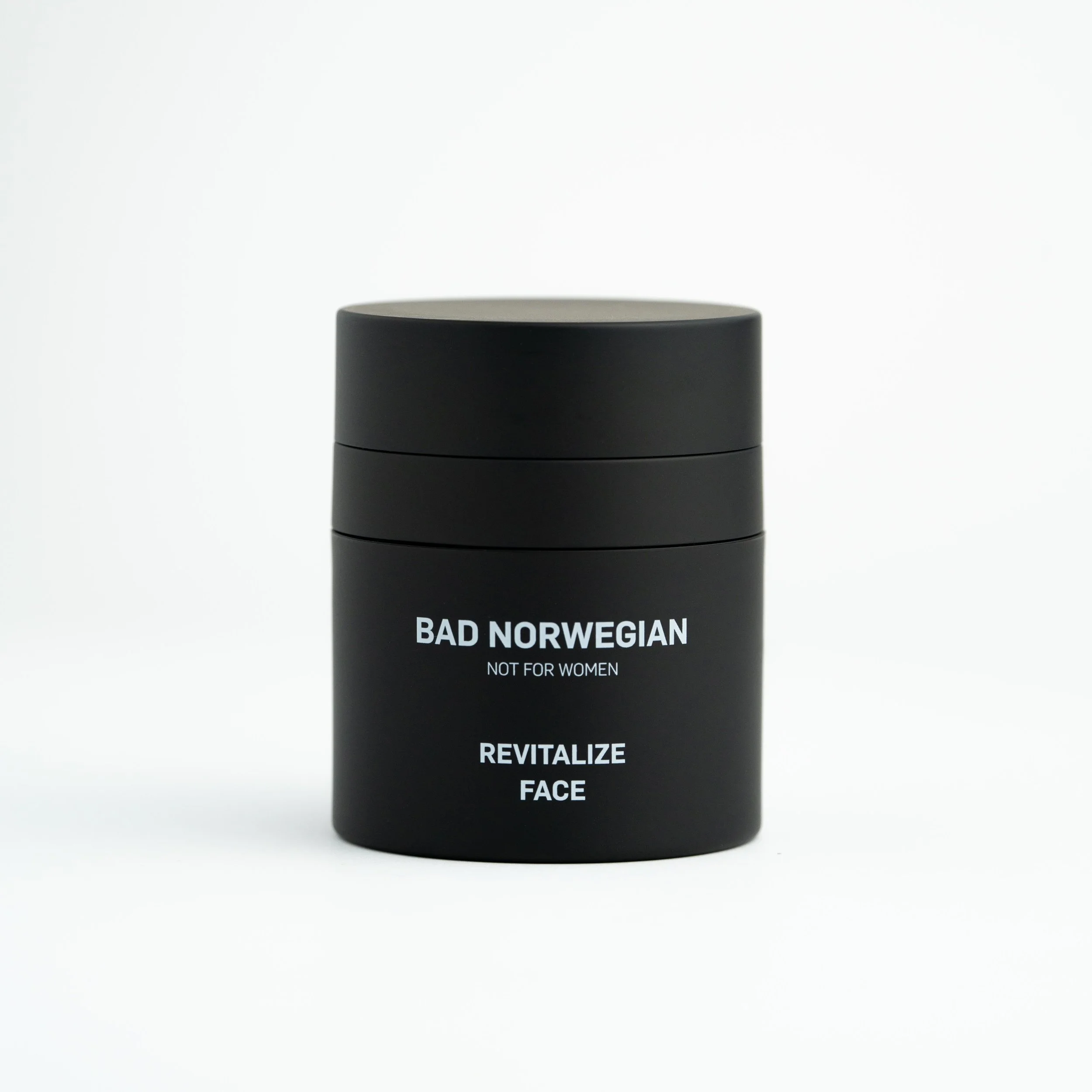 Svart emballasje med tekst: Bad Norwegian, Not for Women, Revitalize Face, på en hvit bakgrunn.