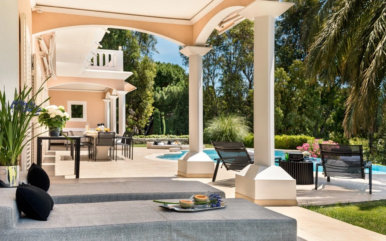 Villa Monaco's outdoor terrace overlooking the heated infinity pool and the Mediterranean Sea — the perfect setting for an evening after a round of golf