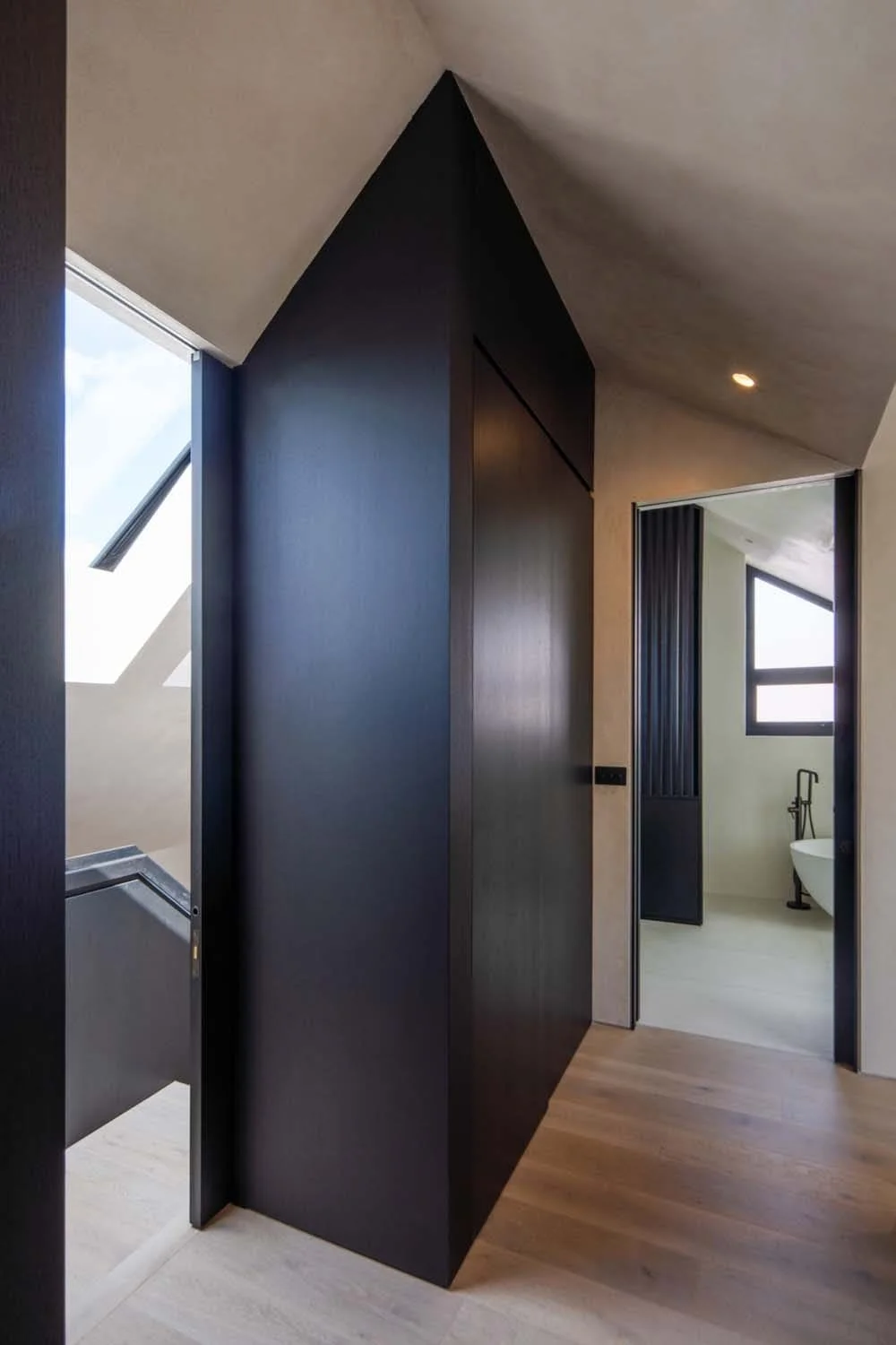 Luxurious top-floor landing with sleek black finishes and soft natural lighting, embodying contemporary London residential interiors