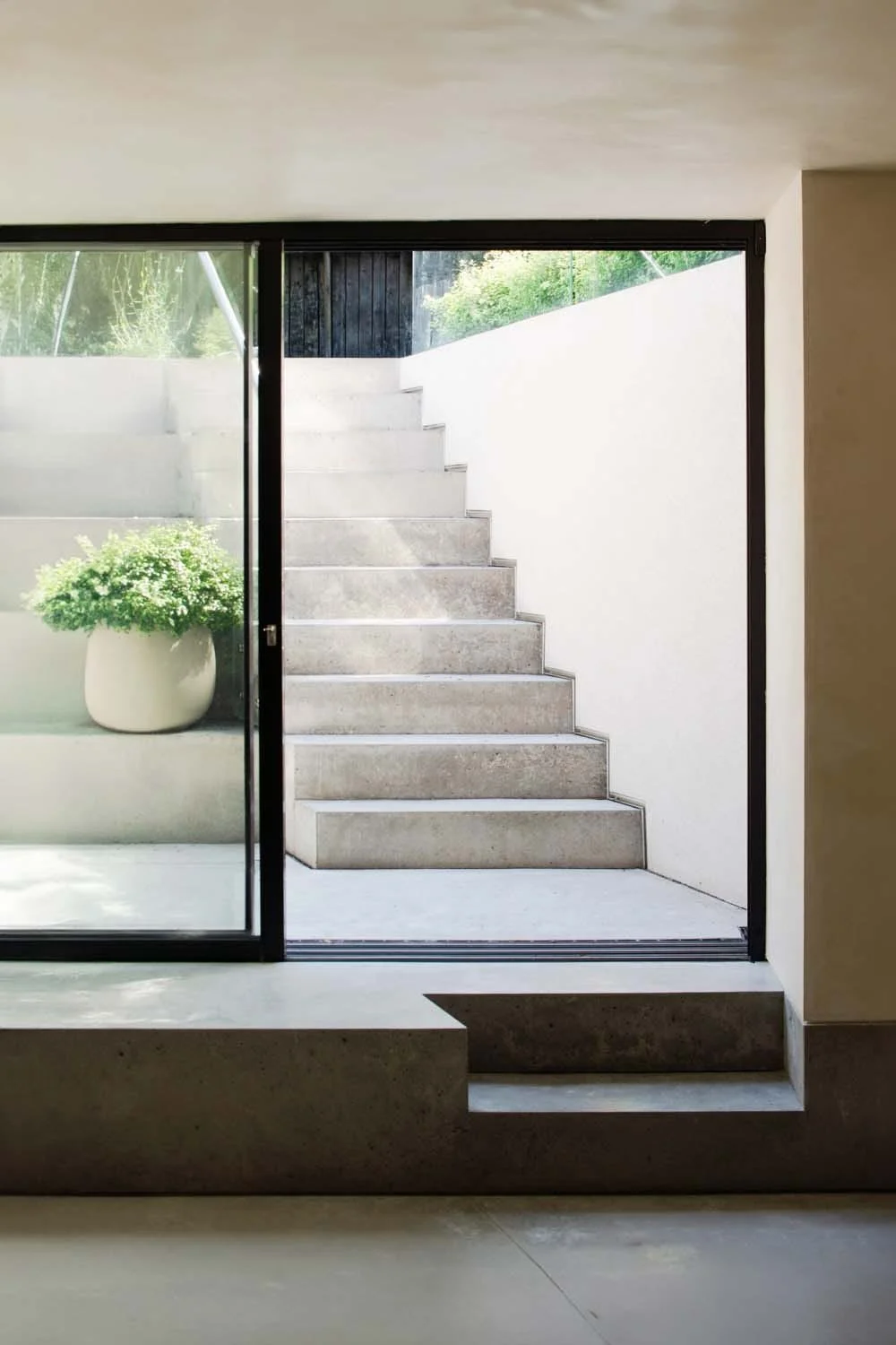 Modern interior view of garden steps, featuring seamless glass doors and natural light, epitomizing elegant luxury living