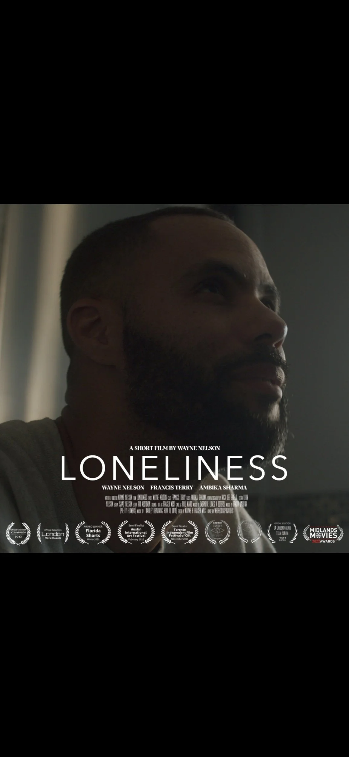 Close-up of a man's face with a beard looking towards the right, with film title "Loneliness" and credits at the bottom, suggesting it is a movie poster.