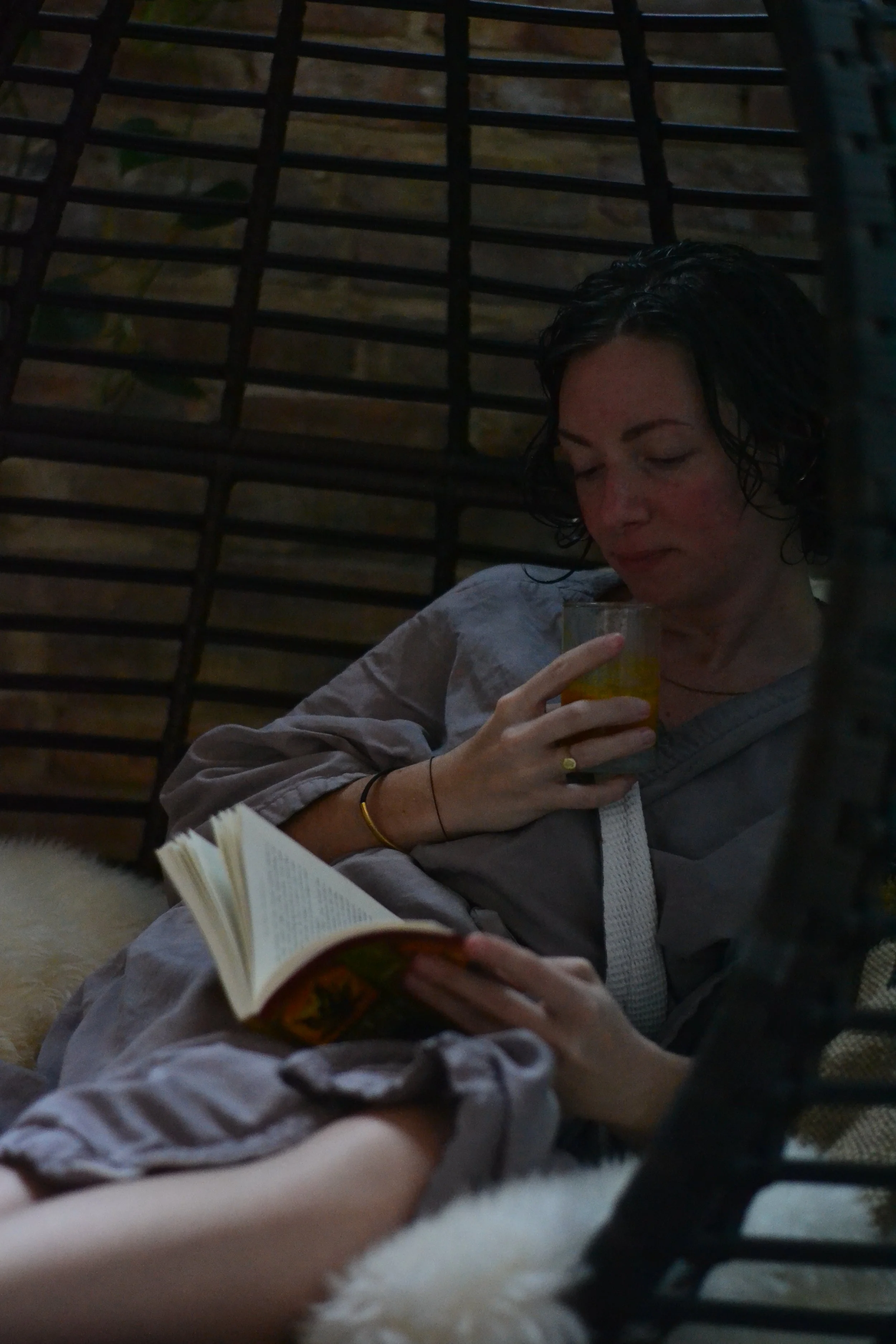 person reading book while drinking beverage