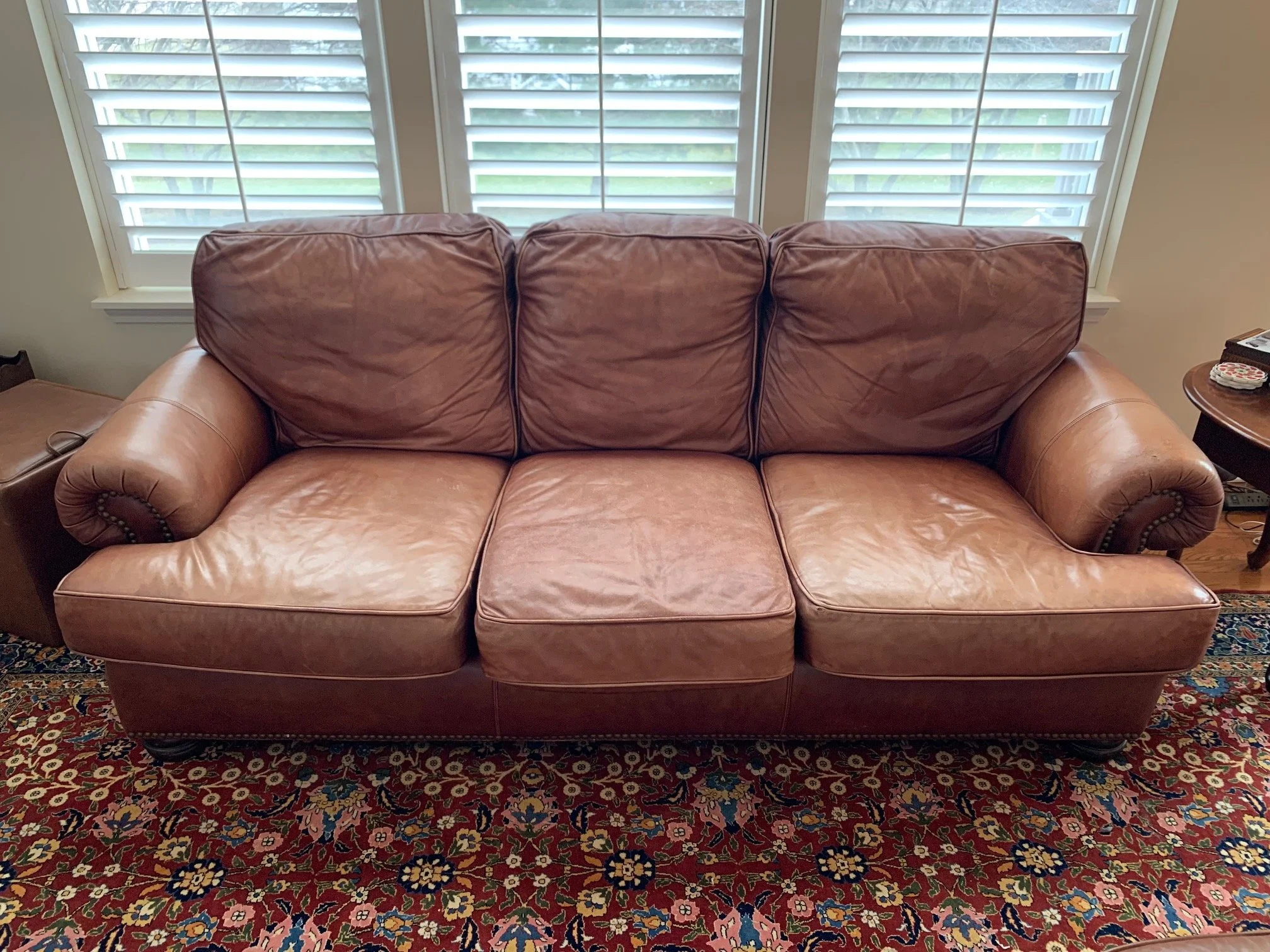 Large 3-seat leather sofa in front room of Chicagoland Suburban home. The leather is worn and faded. needs to be re-colored.