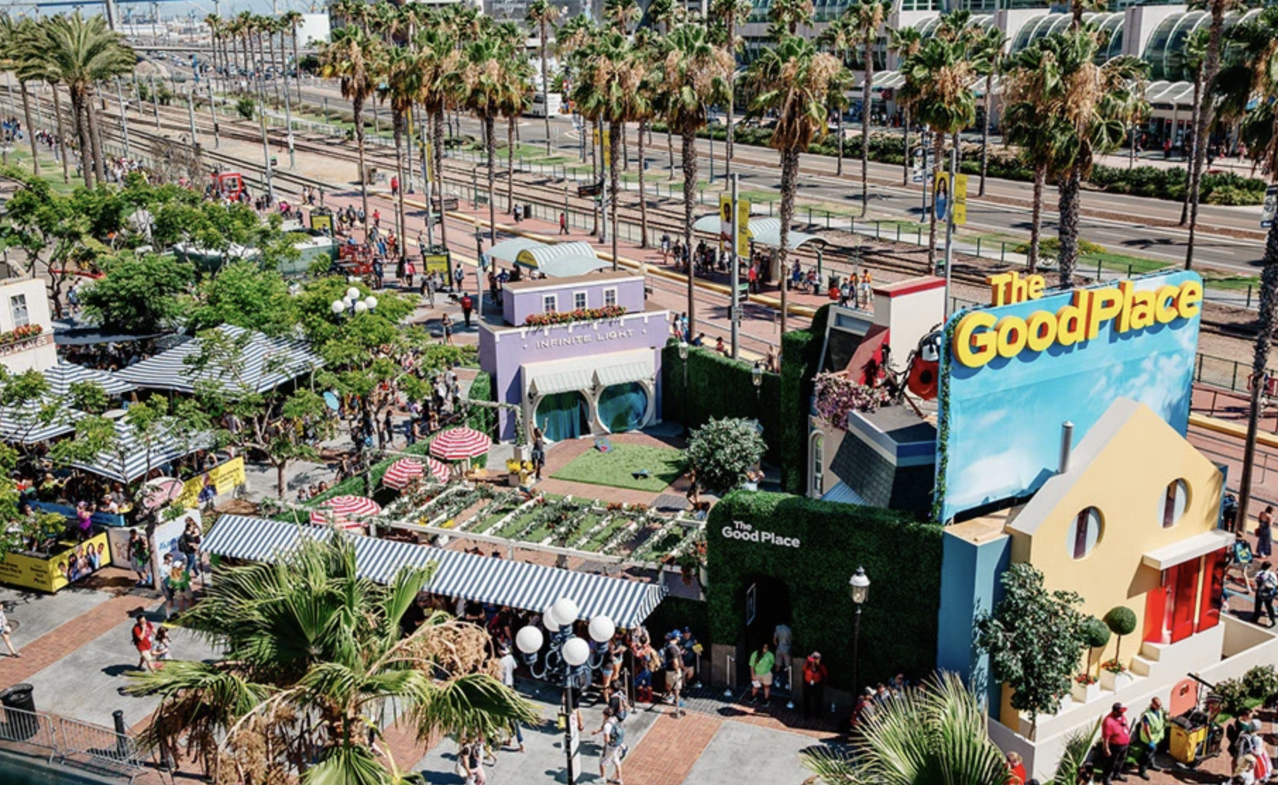 Two people working at a wooden desk with laptops, printed documents, pens, and a computer mouse in a collaborative meeting.