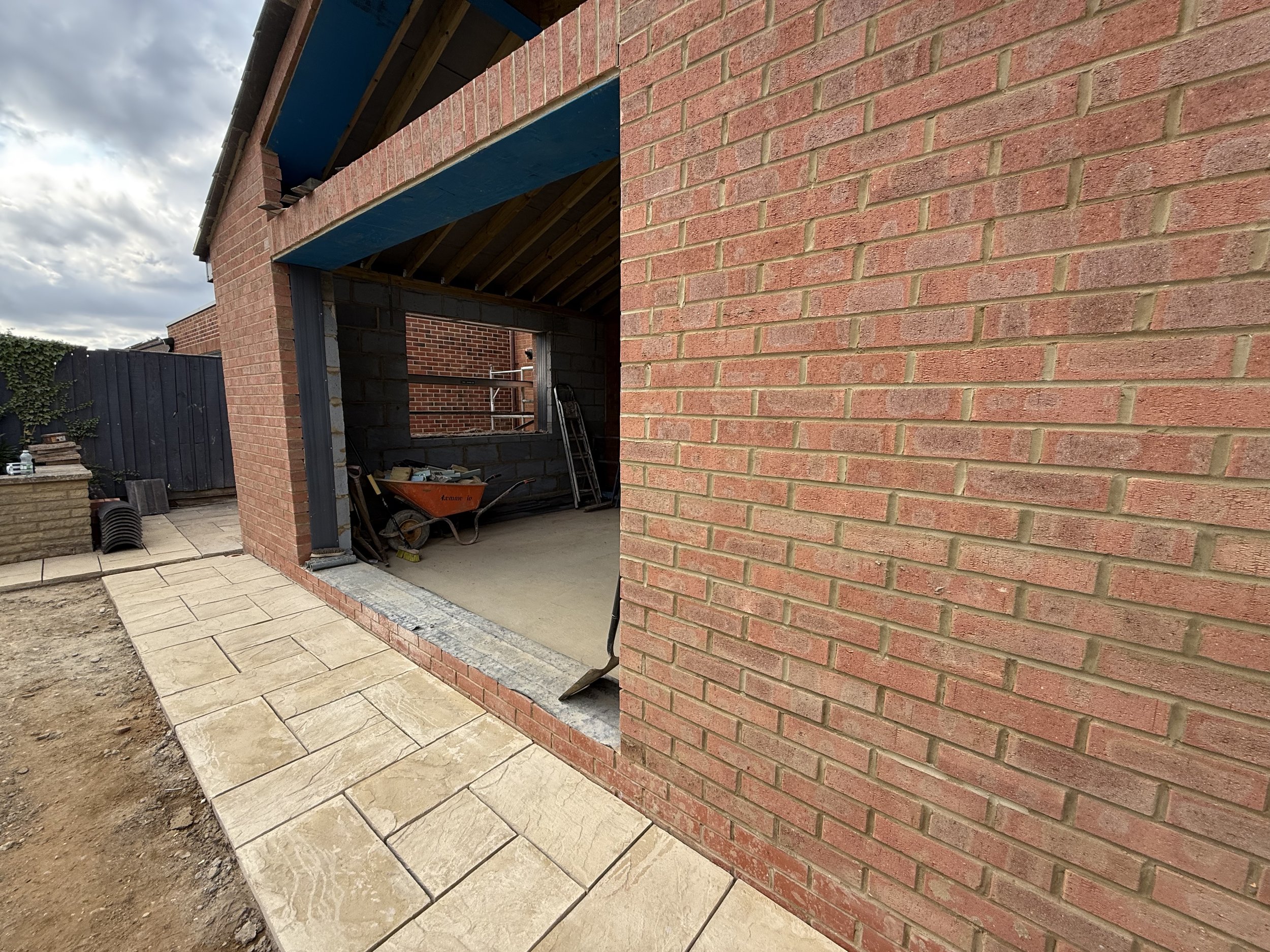 High-quality brick single storey extension under construction with structural steel opening and premium sandstone paving at a private Oxfordshire home