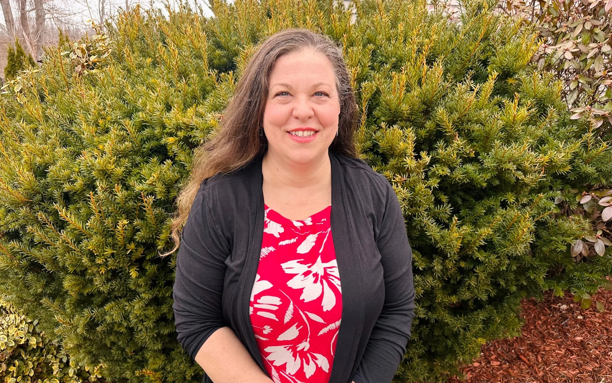 Sherie in a restaurant holding a menu and smiling.