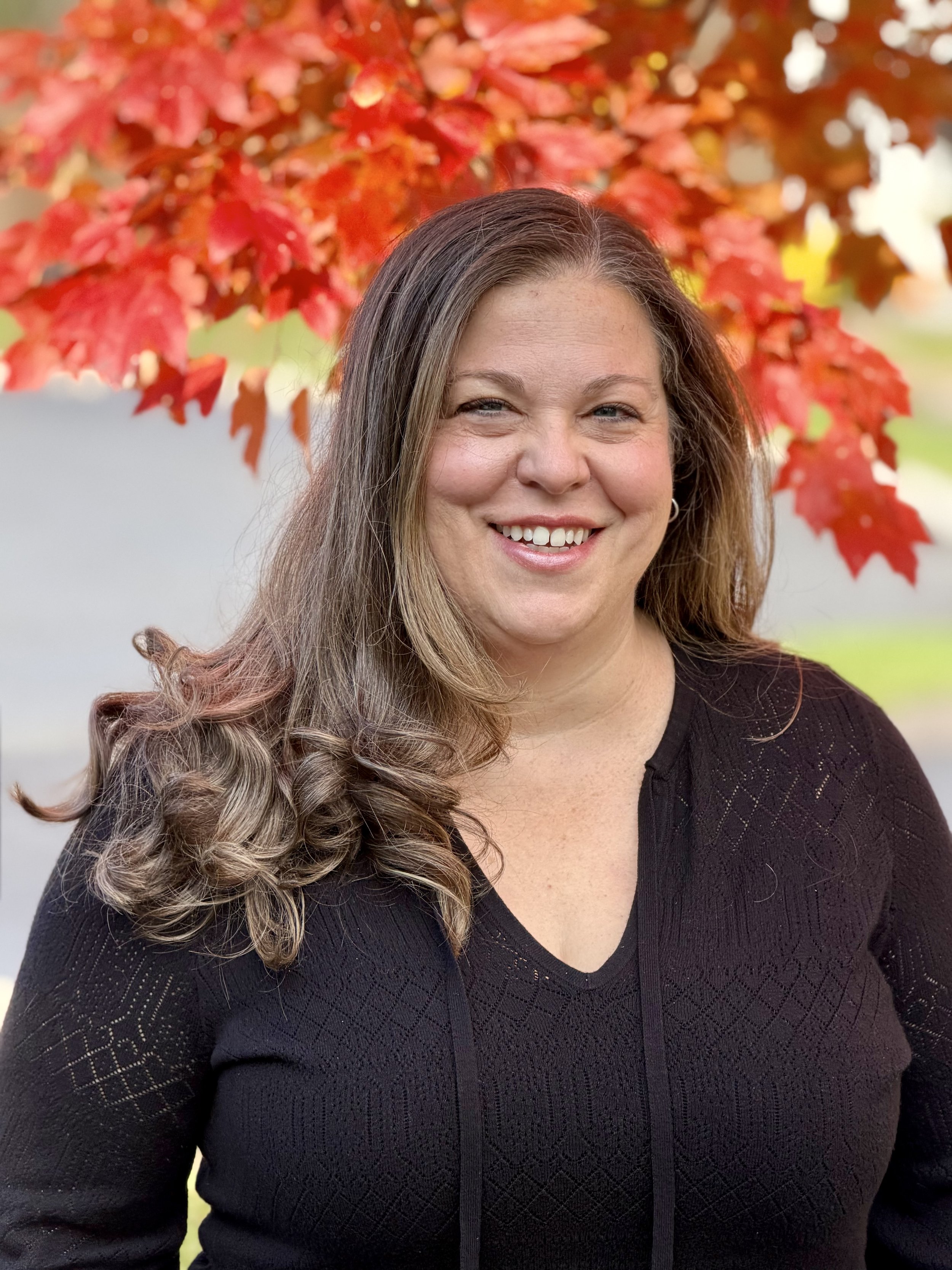 Sherie in a restaurant holding a menu and smiling.