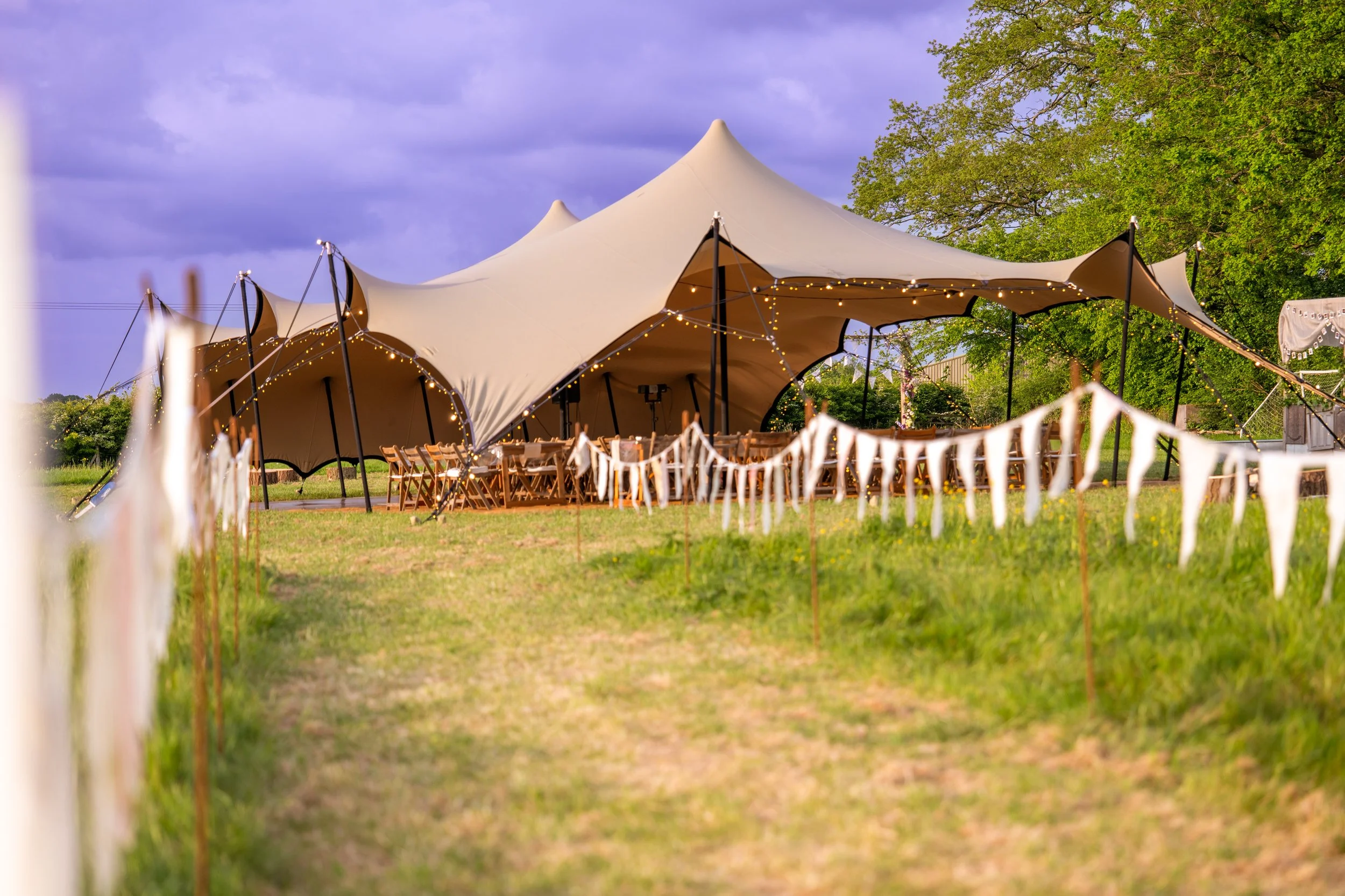 beautiful marquee at the end of a bunting lined path