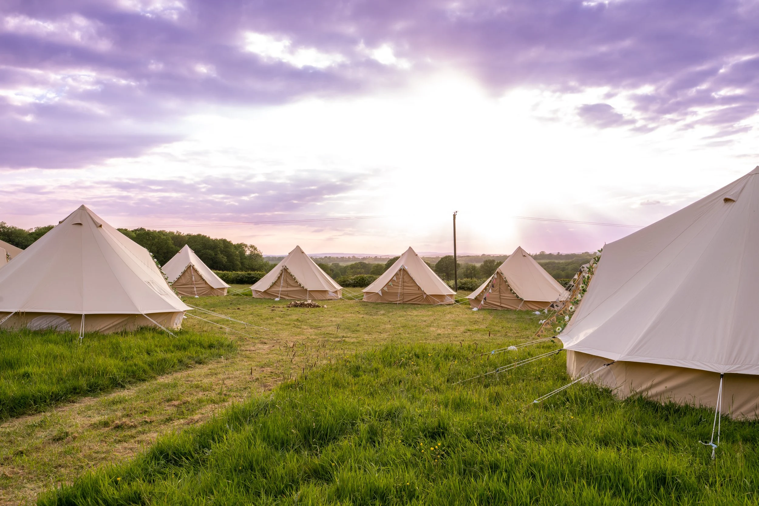 a group of bell tents set up in the field