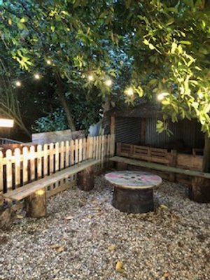 Outdoor seating area with wooden benches and a large spool table.