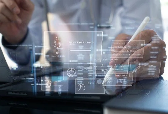 A person using a stylus to interact with a transparent digital medical interface showing human anatomy and health data.