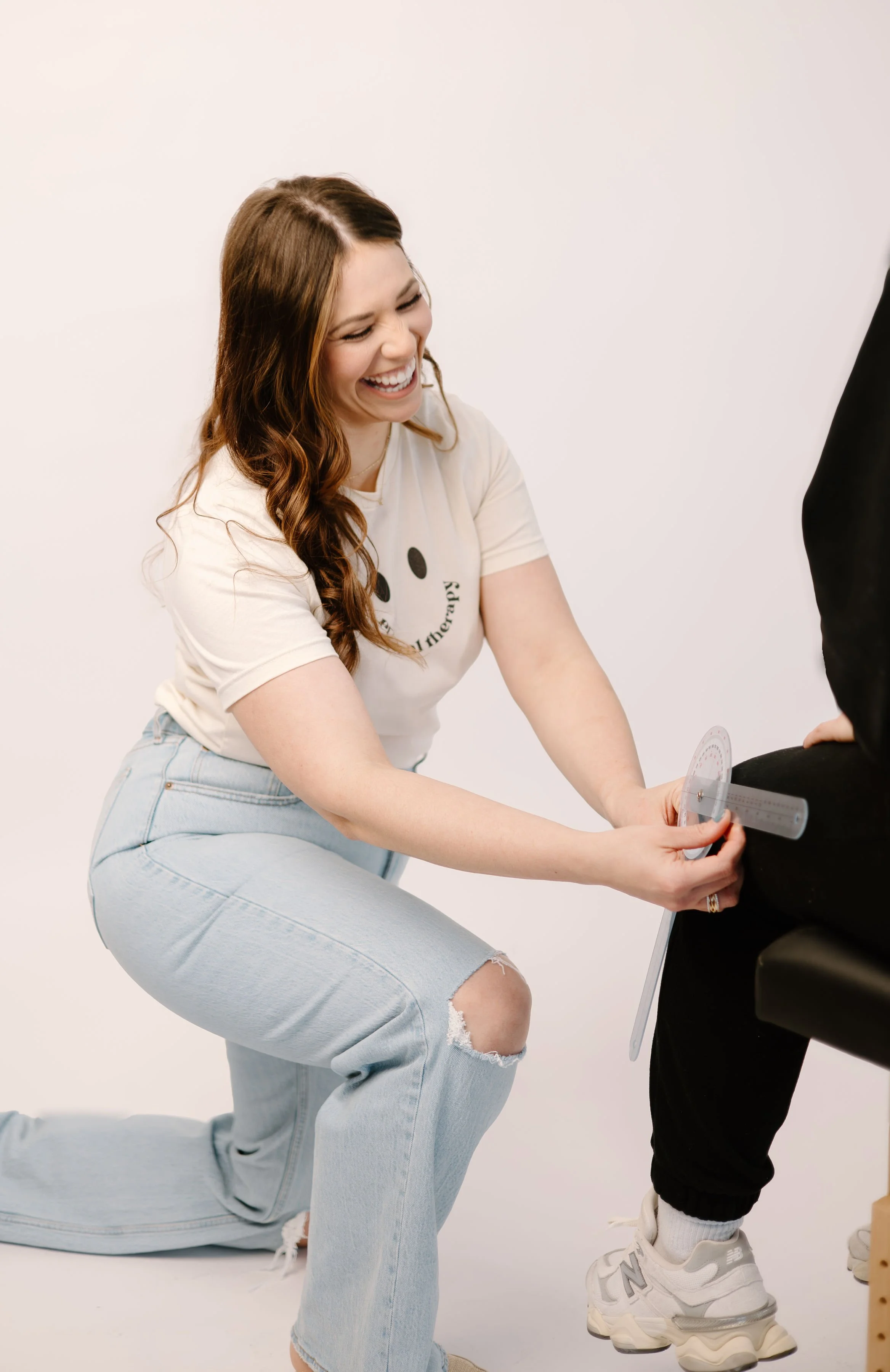 A physical therapist performing a movement assessment with a patient in a modern clinic setting