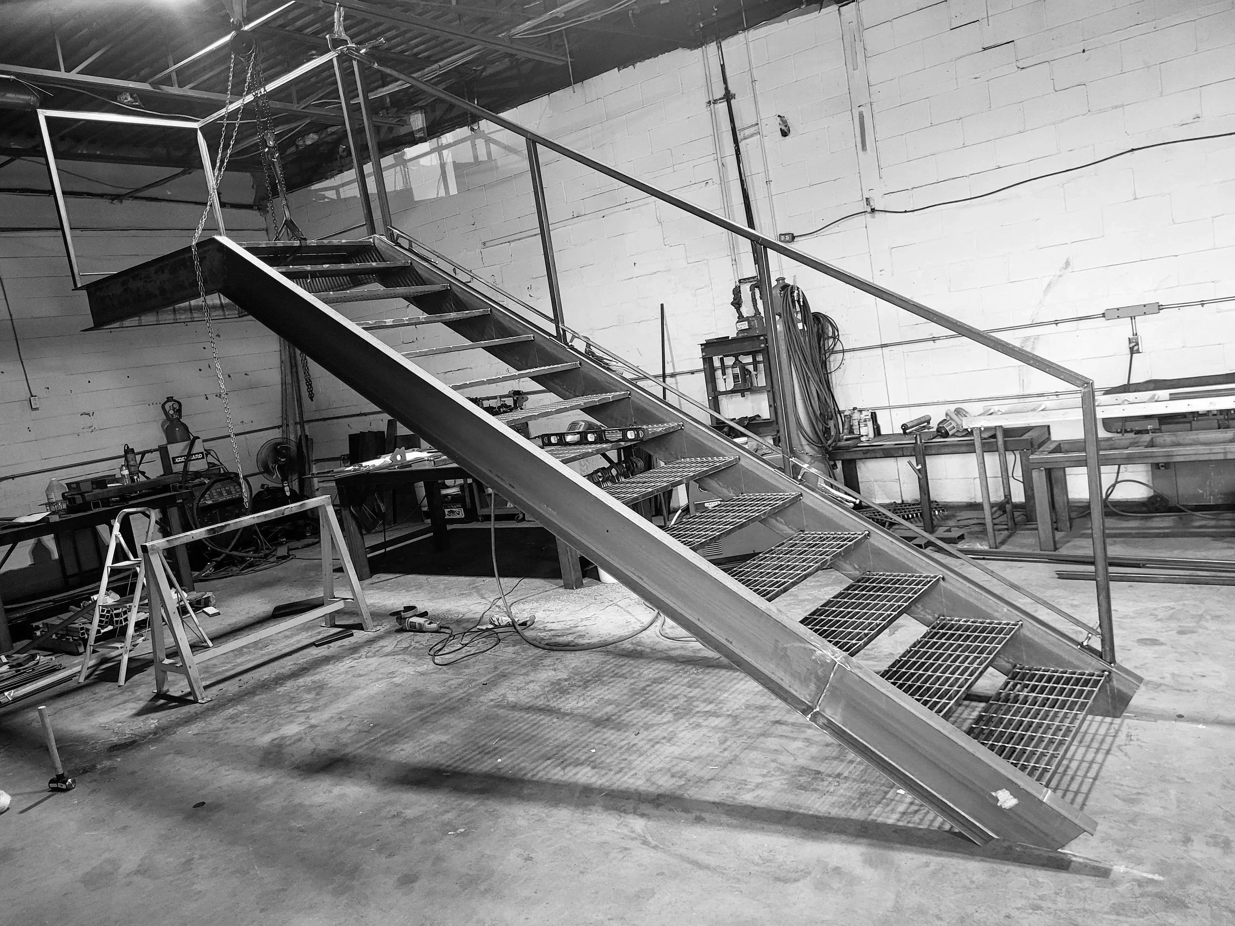 Structure brute complète d'un escalier de sortie d'urgence en acier avec ses limons et garde-corps, prête pour la galvanisation en usine.
